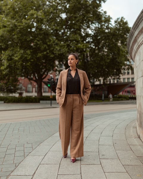 Woman in a suit walks down a city street.