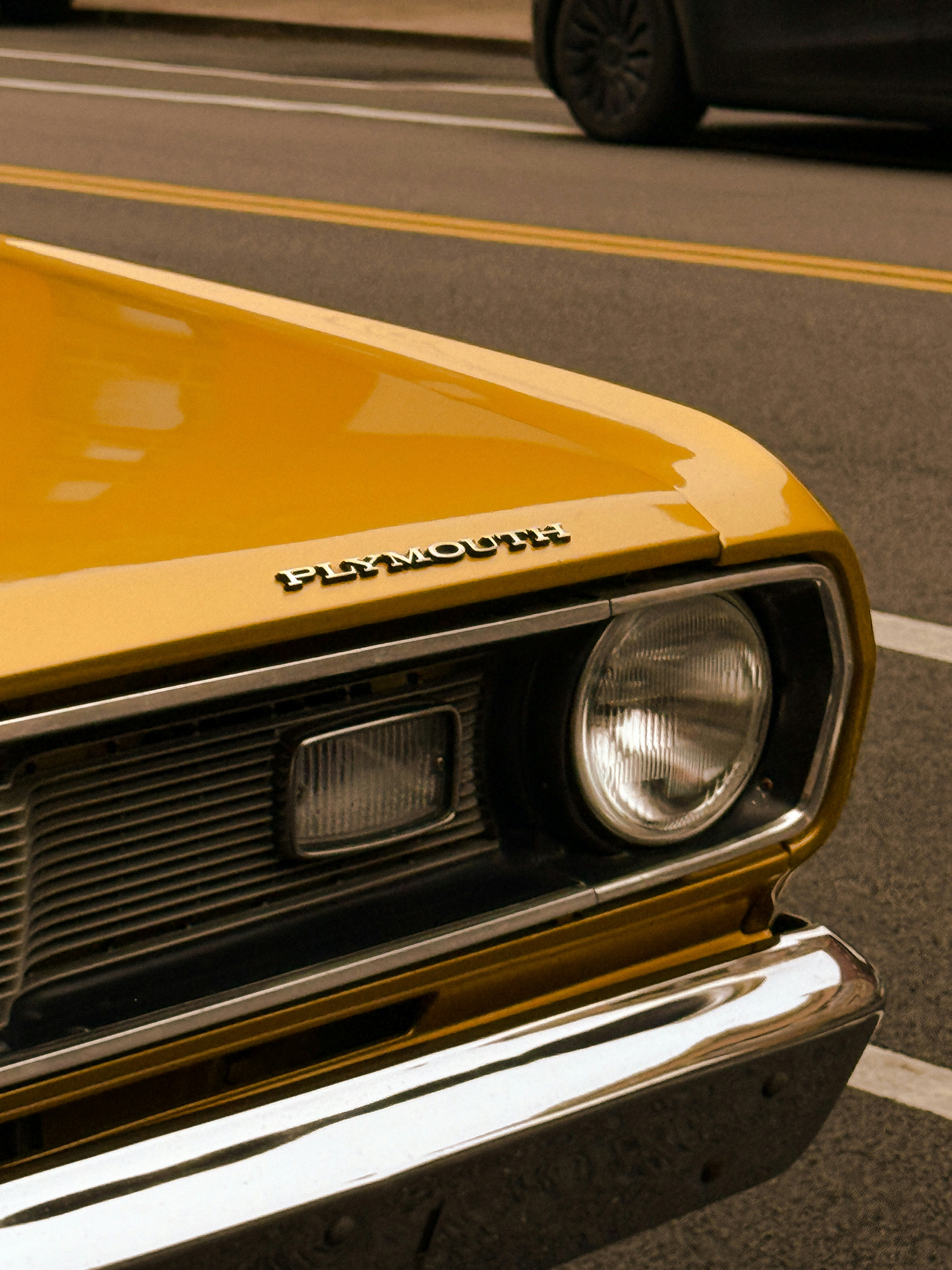 Un primo piano di una classica auto plymouth gialla.