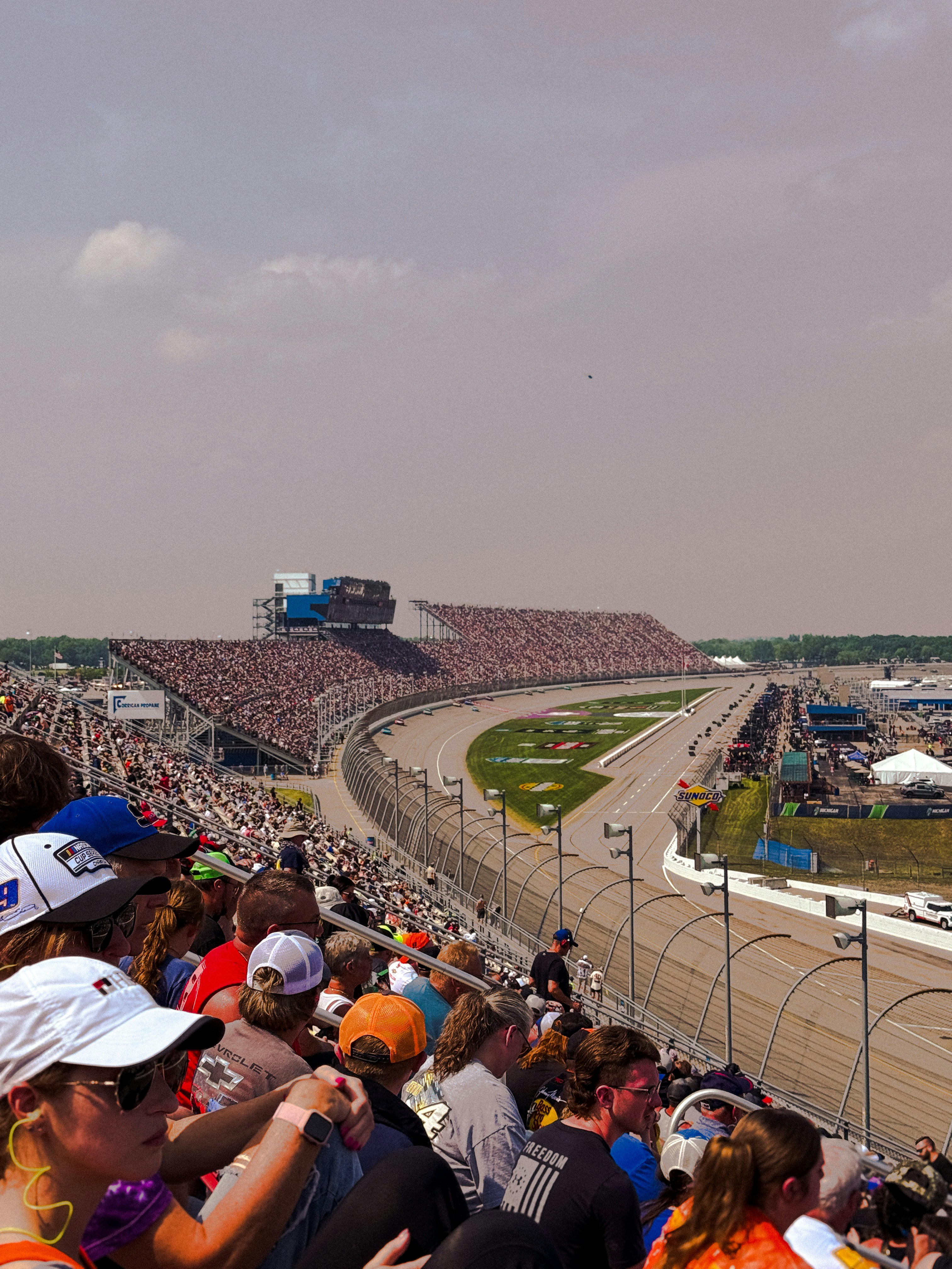 Gli appassionati di corse guardano una gara automobilistica dagli spalti.