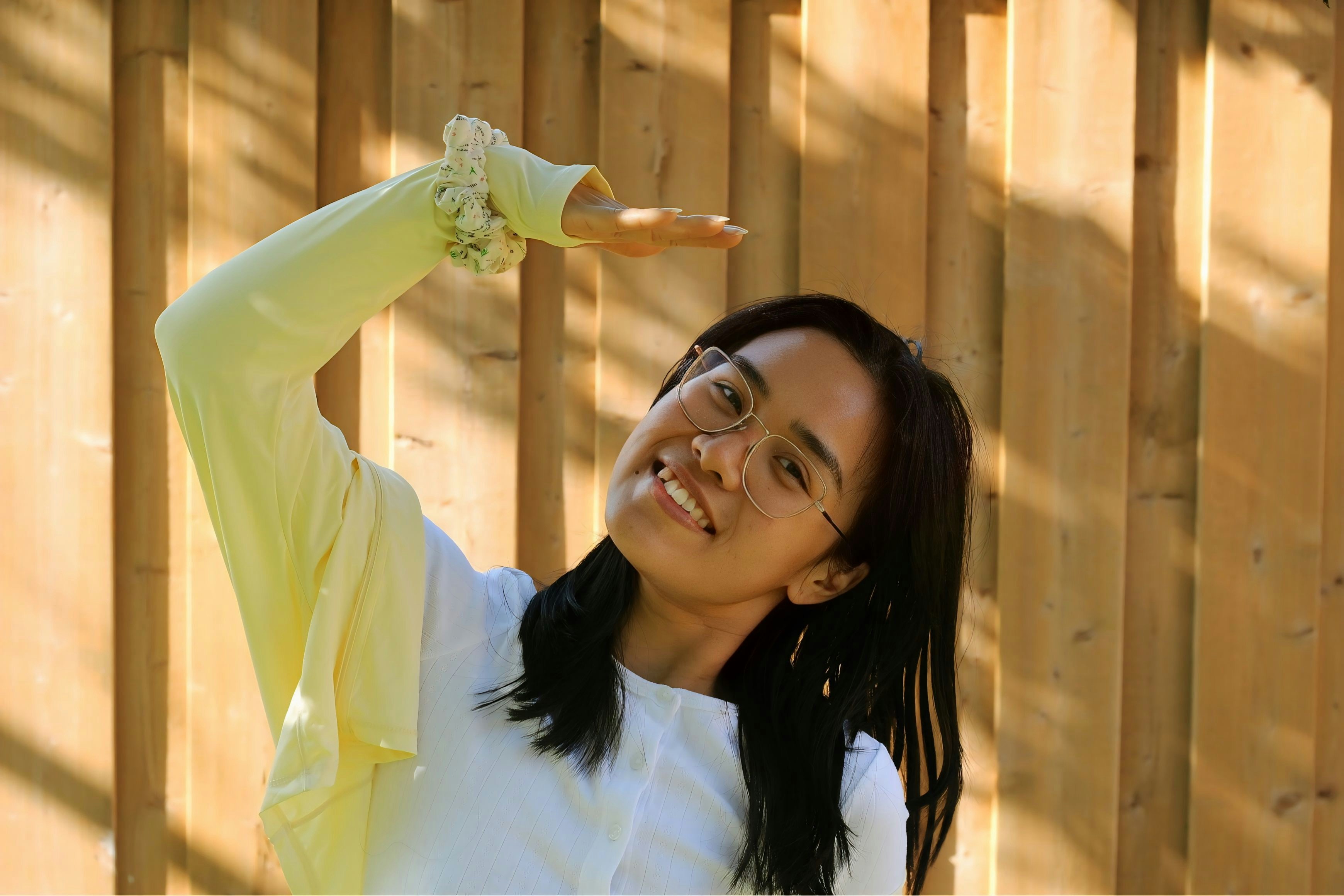 Woman poses against a wooden background.