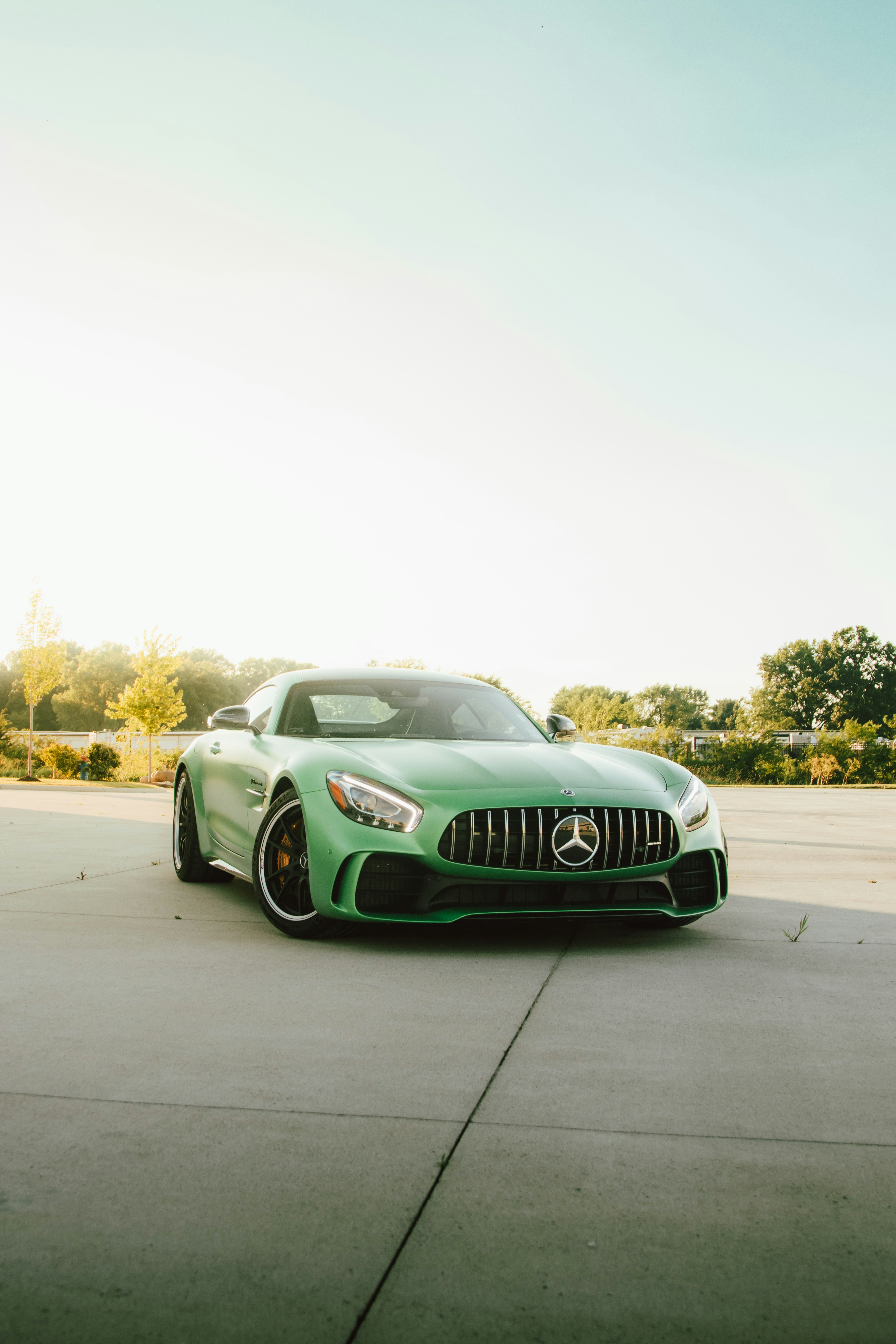 A green mercedes-amg gt sits on concrete.