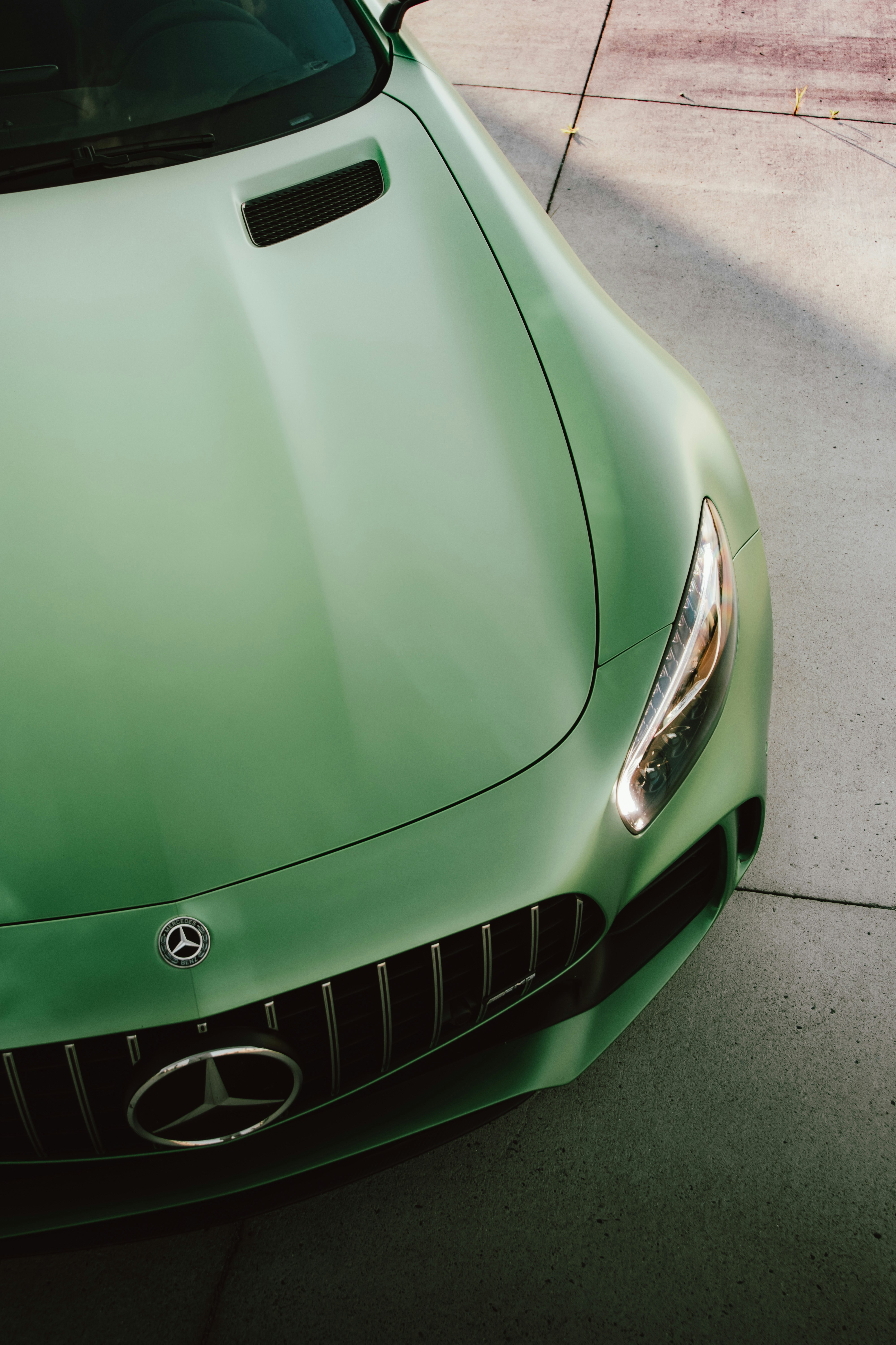 A green mercedes benz car's frontal view.