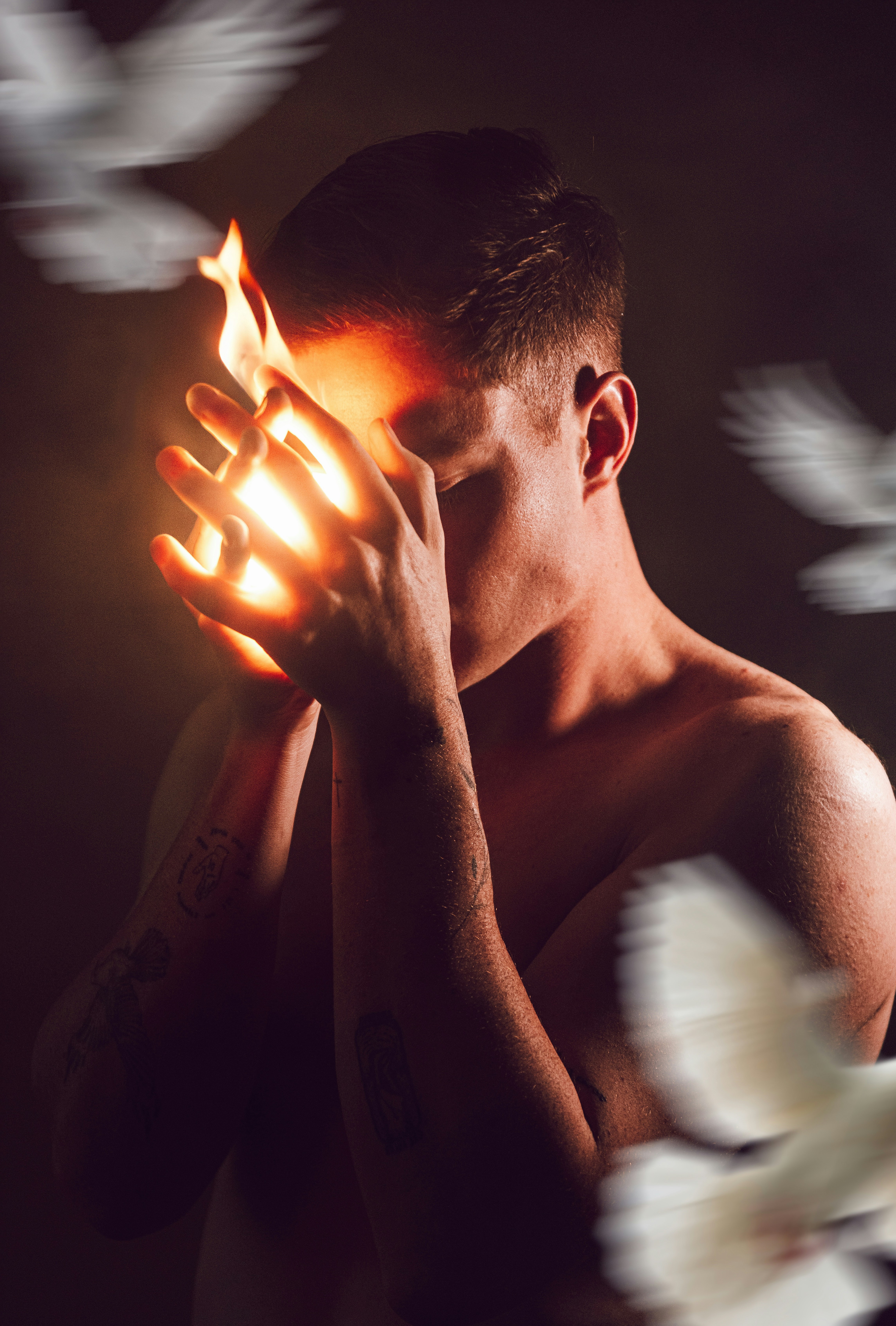 Der Mensch hält das Feuer in den Händen mit verschwommenen Tauben.