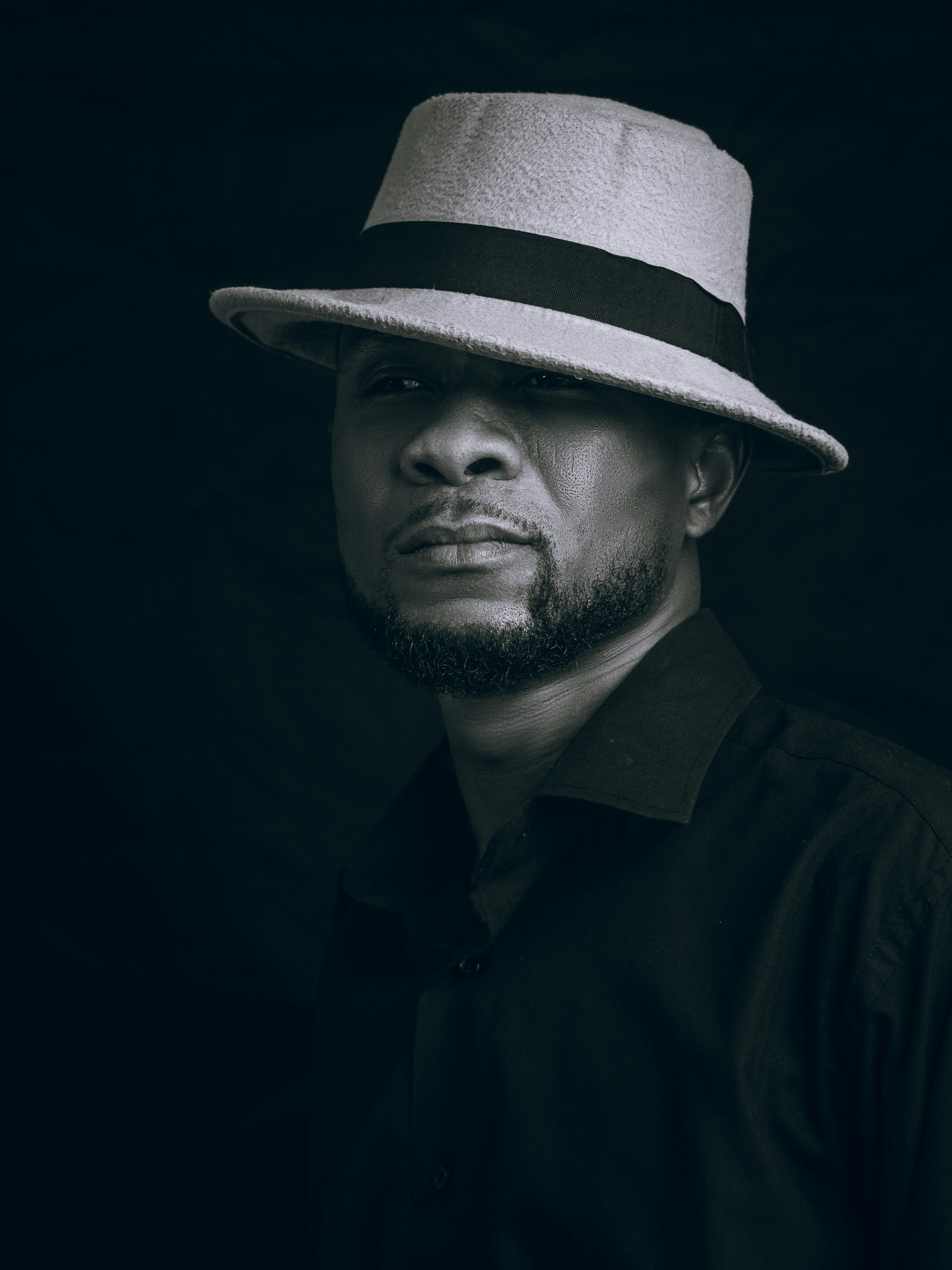 Man wearing a hat stares intensely at the viewer.