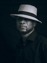 Man wearing a hat stares intensely at the viewer.