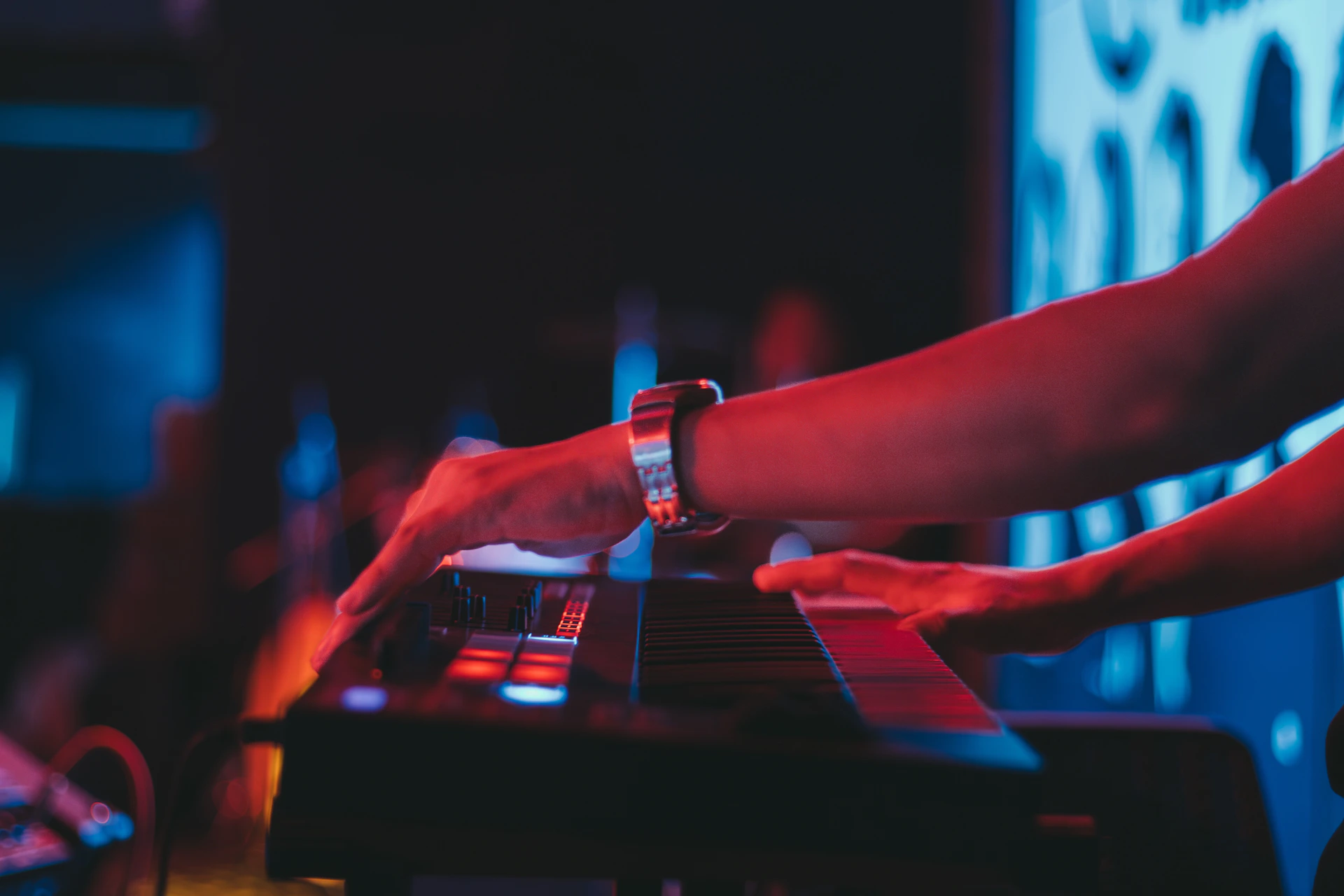 A person's hands play electronic music.