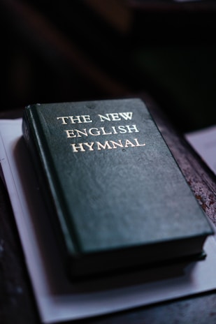 A green book reveals "the new english hymnal".