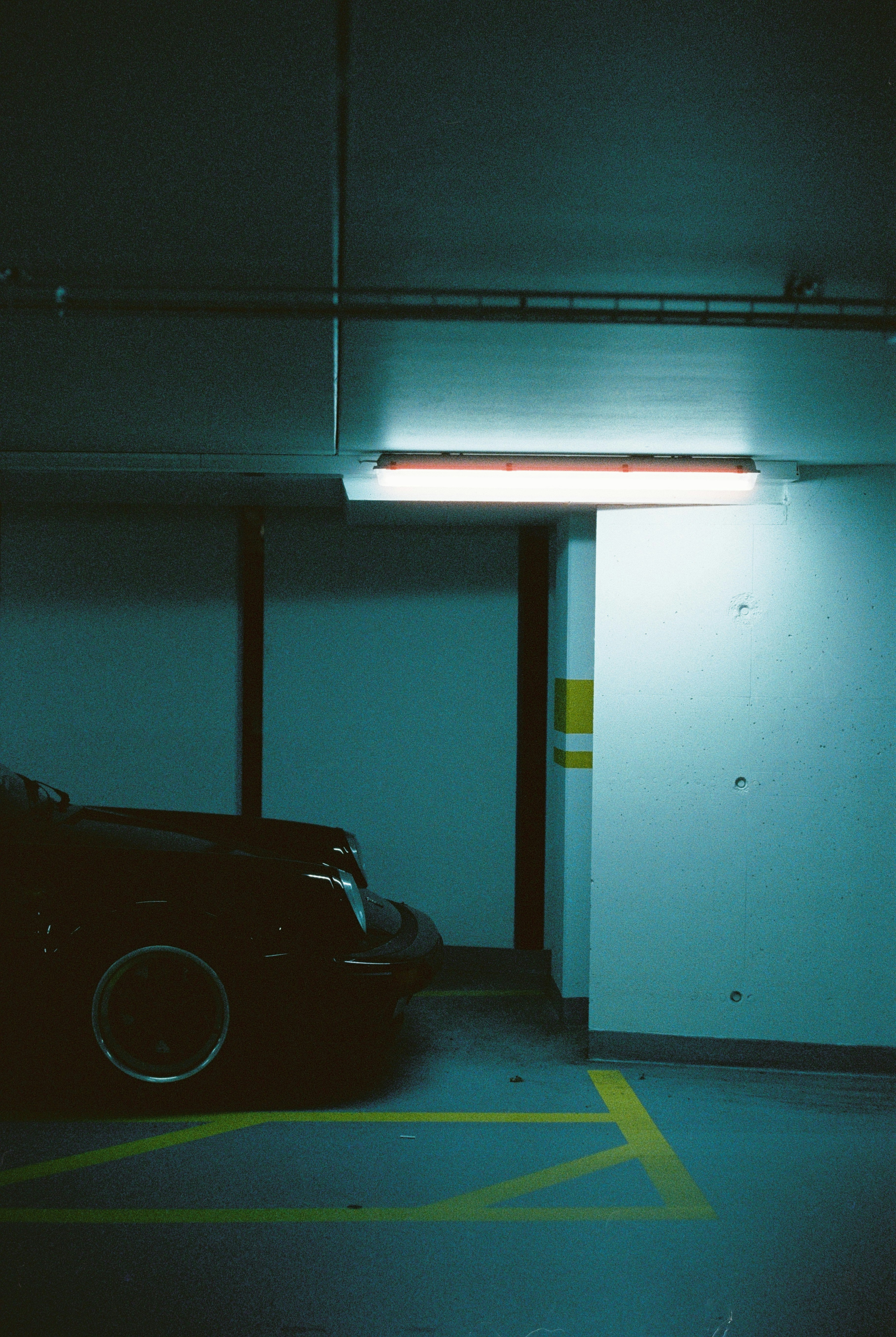 A car is parked in a dark parking garage.