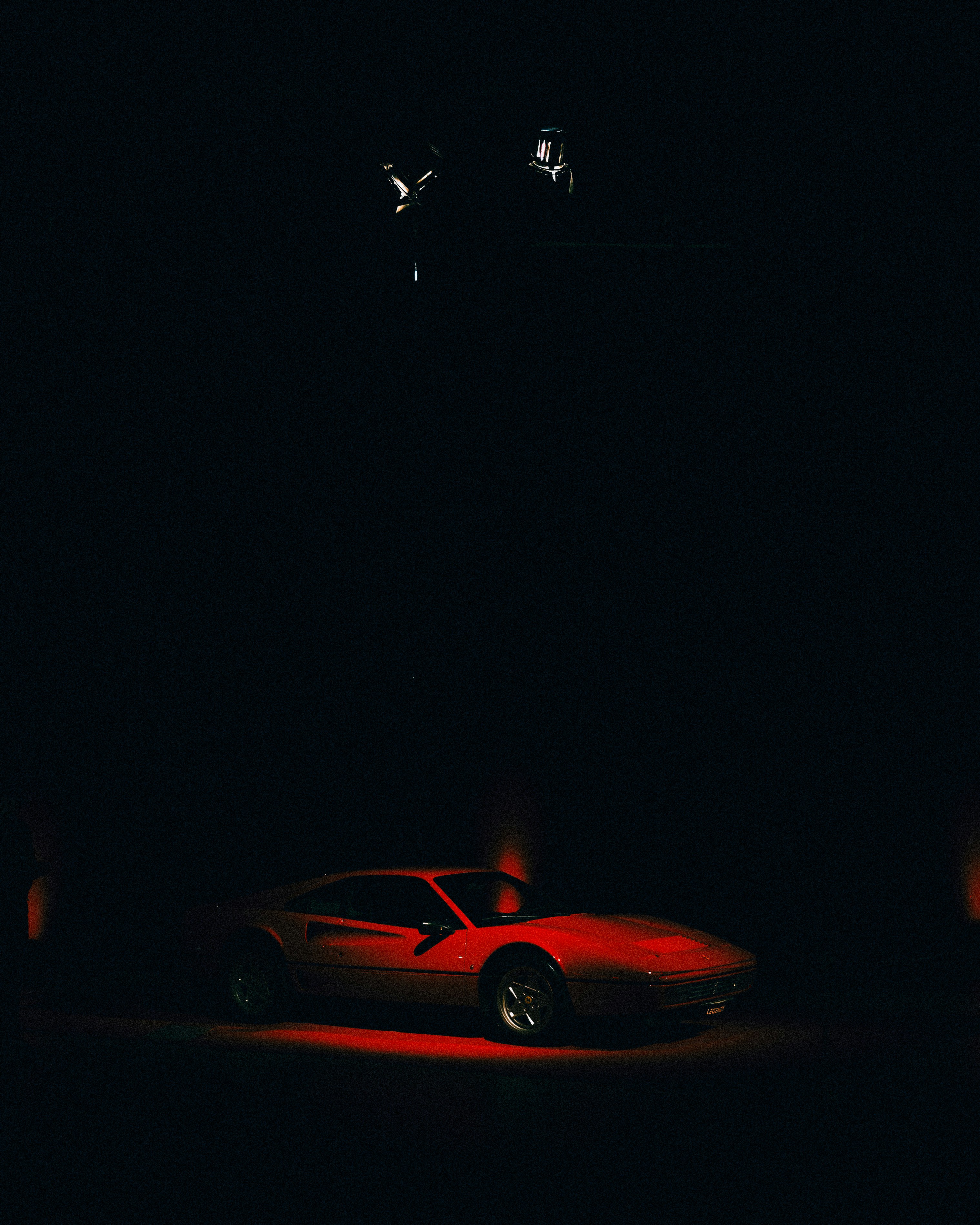 A black exotic coupe under low studio light