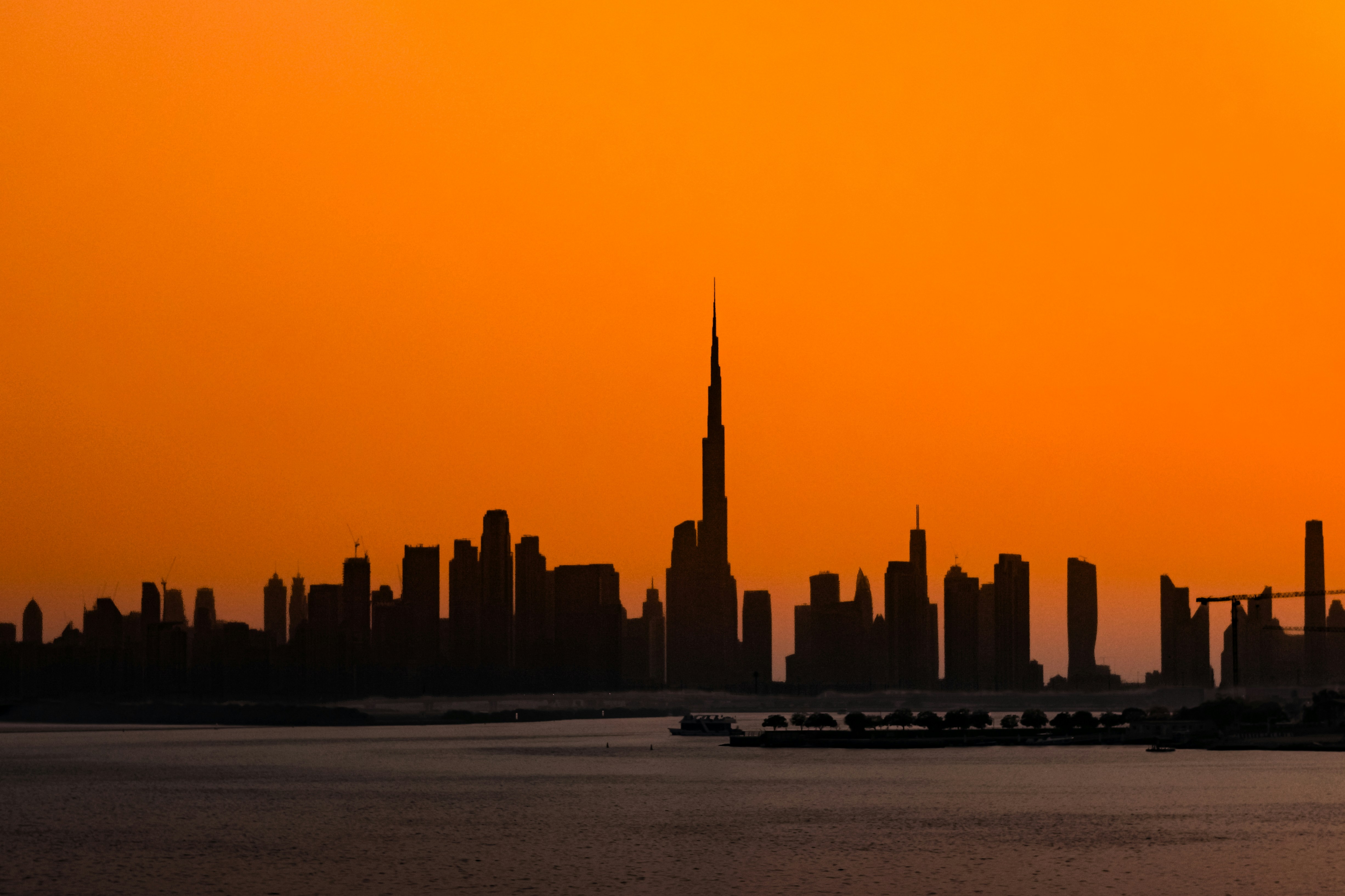 A breathtaking silhouette of the Dubai skyline captured during golden hour, with the iconic Burj Khalifa piercing through a dramatic orange sky. The calm waters in the foreground contrast beautifully against the sharp, black shapes of the city’s towering architecture. This image perfectly encapsulates the serenity and scale of Dubai at sunset. Camera: Canon EOS R50 Lens: RF-S 18-45mm Shutter Speed: 1/500 sec Aperture: f/5.6 ISO: 200 Focal Length: 45mm