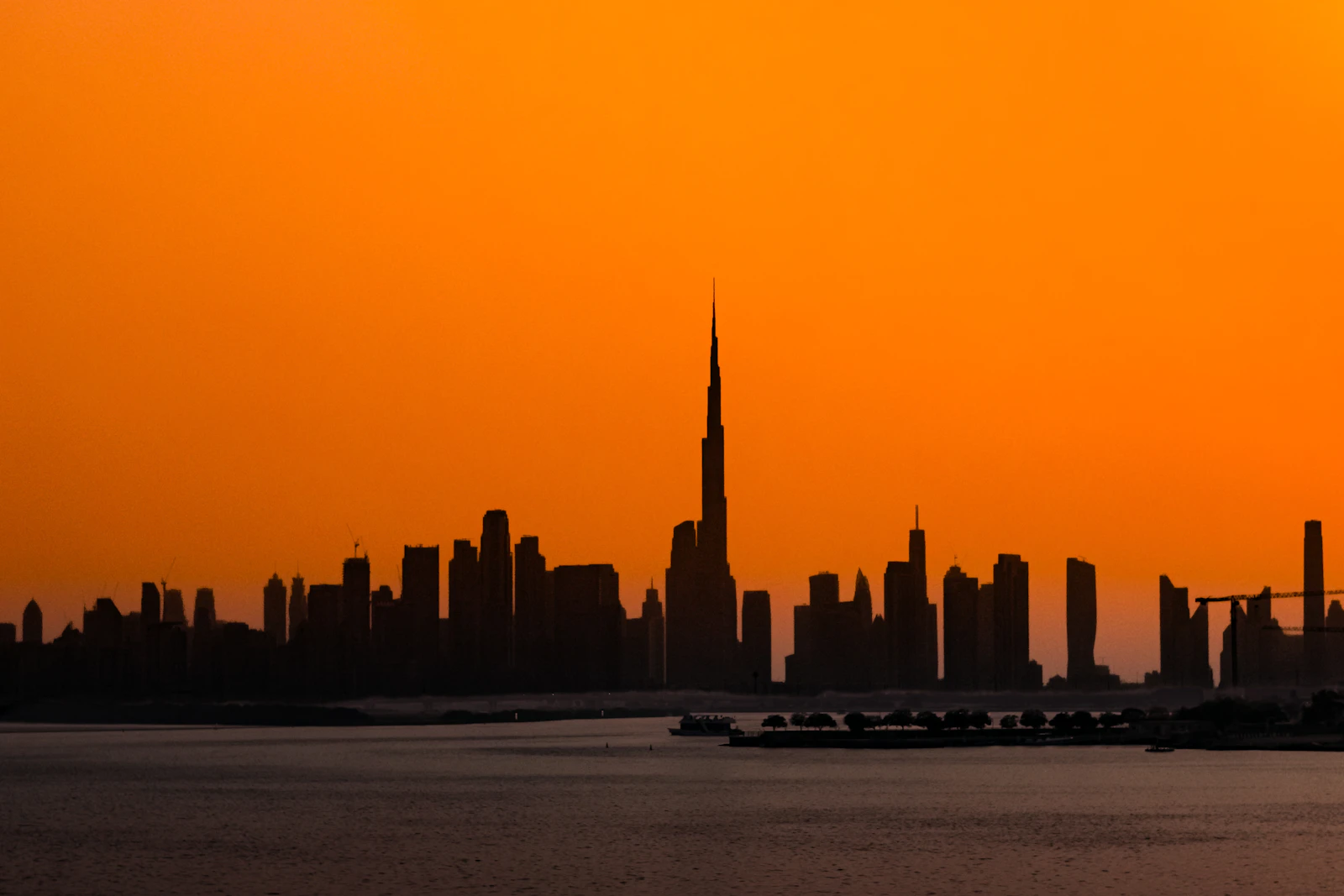 Dubai skyline with Burj Khalifa silhouetted at sunset
