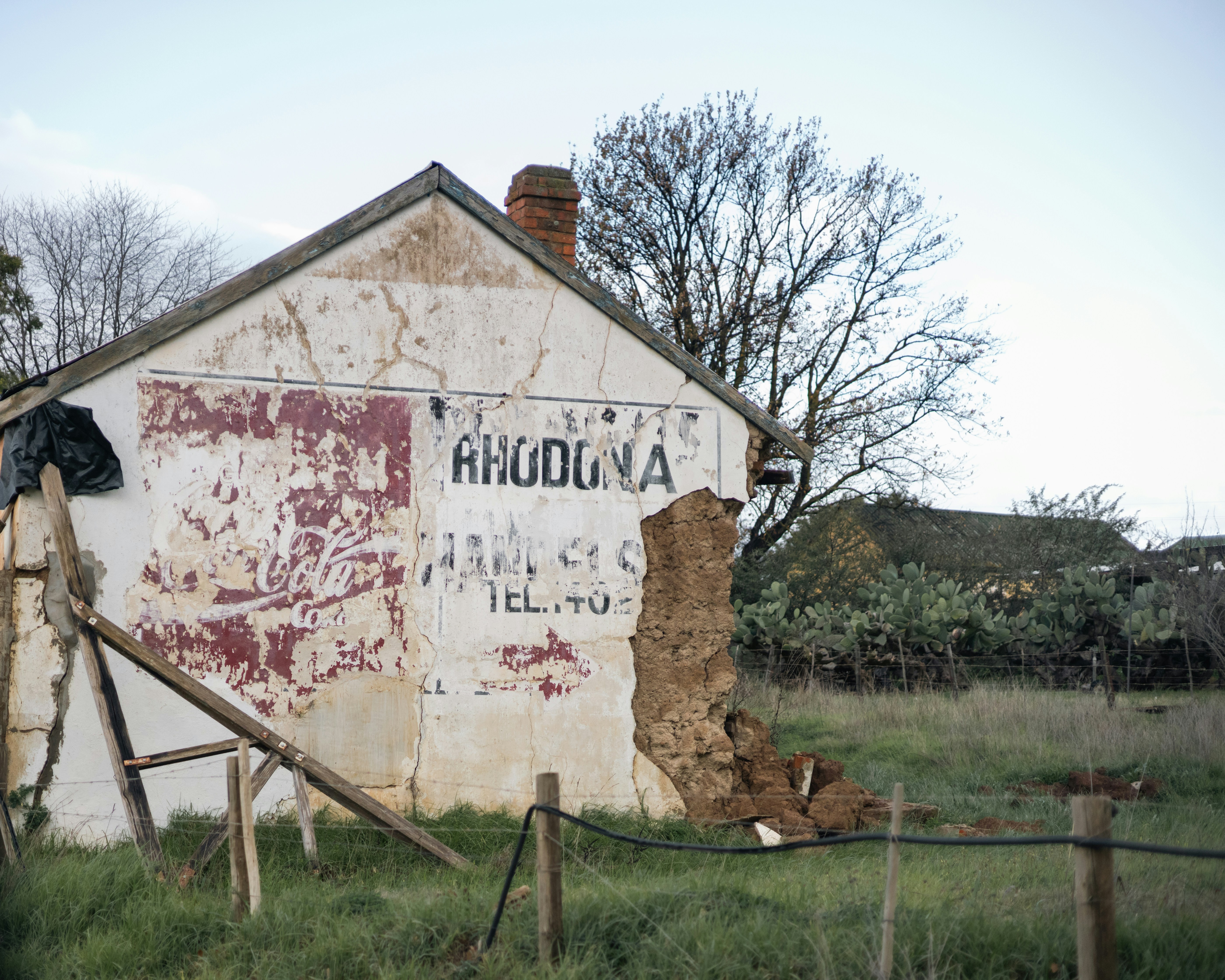 Edificio en ruinas con pintura descascarada y daños.