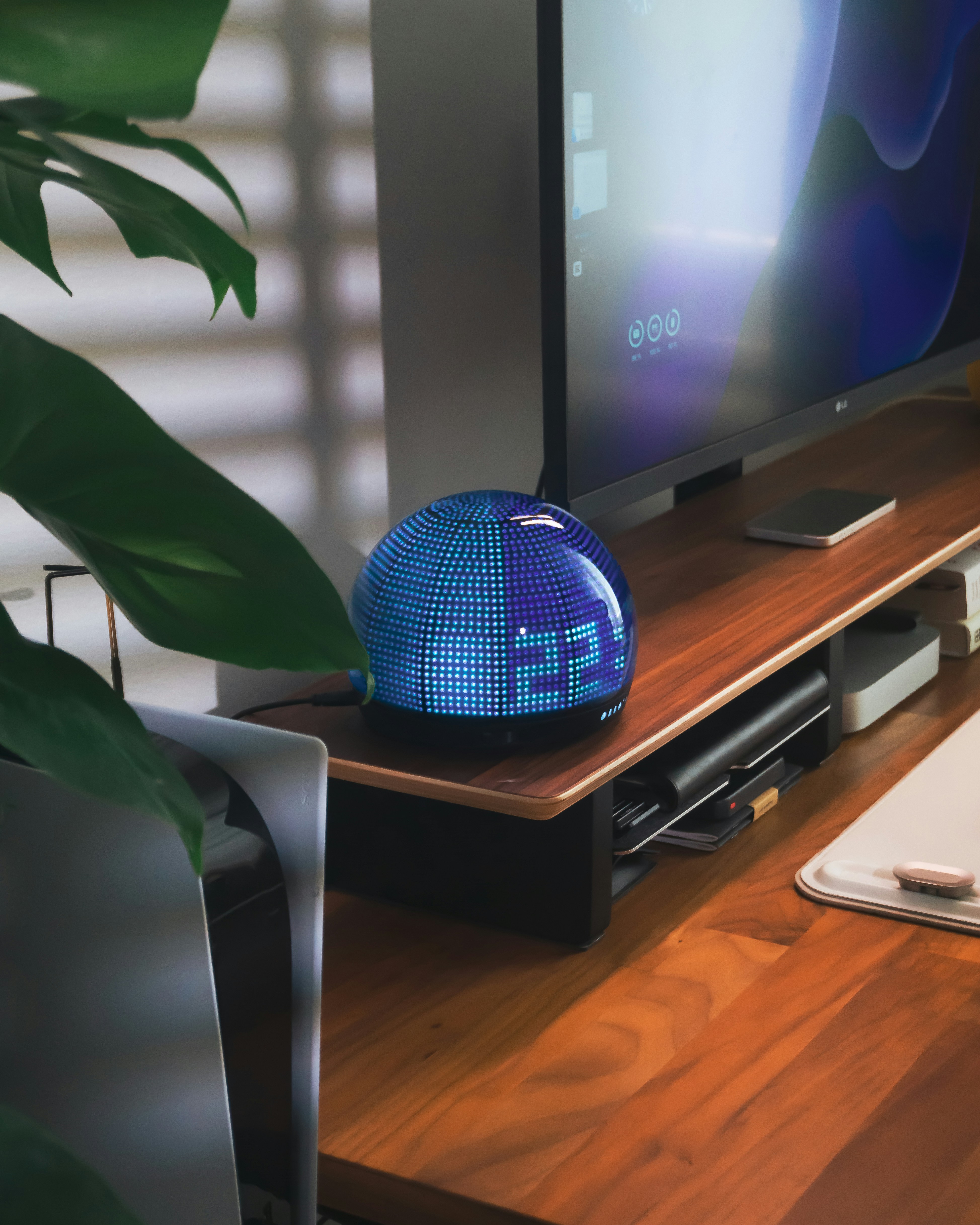 A blue led clock sits on a wooden desk.