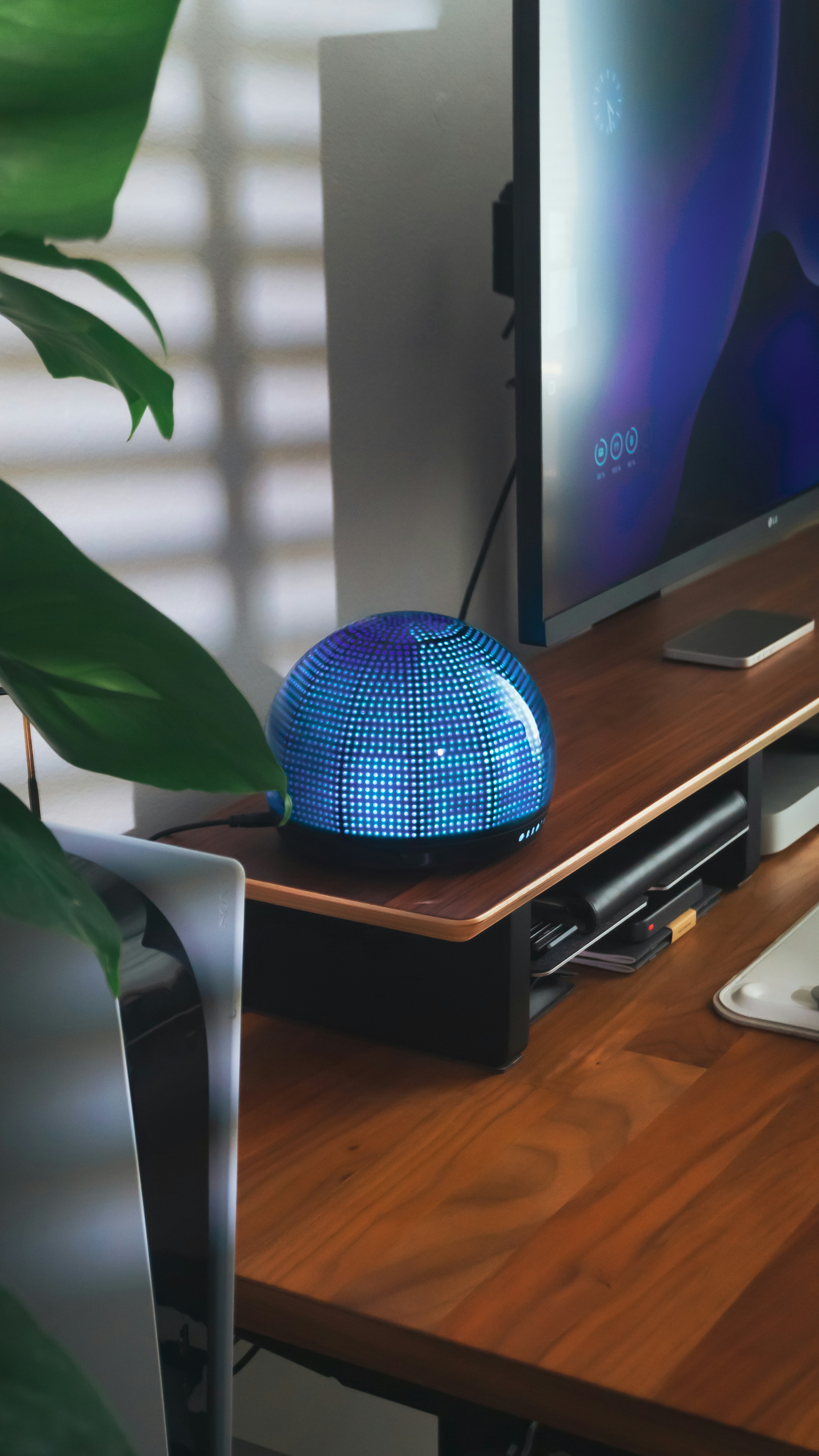 A glowing device sits on a wooden desk.