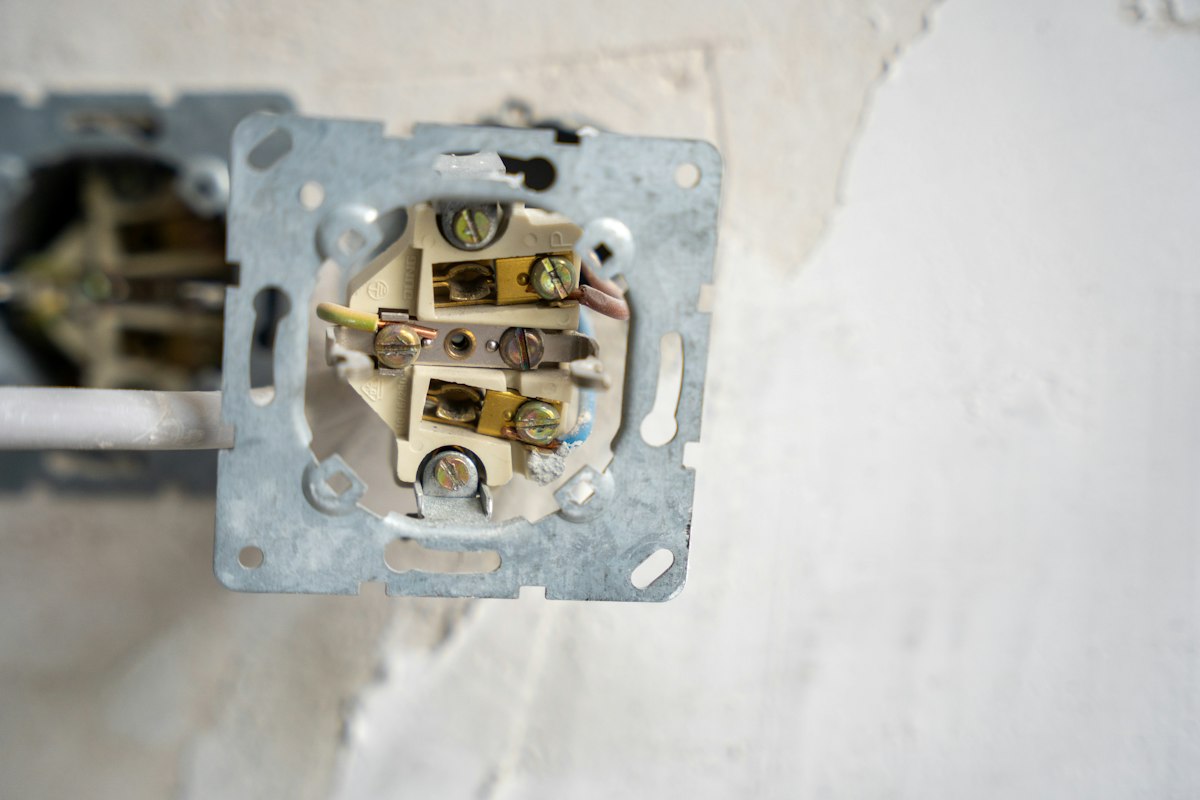 Caixa elétrica aberta mostrando fios coloridos e bornes