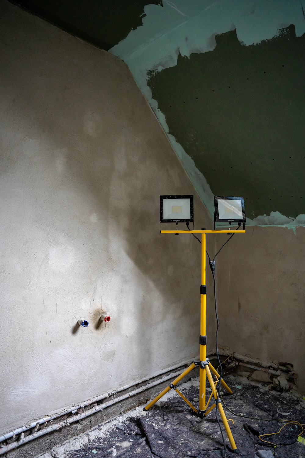 Interior space with freshly plastered walls under work lights
