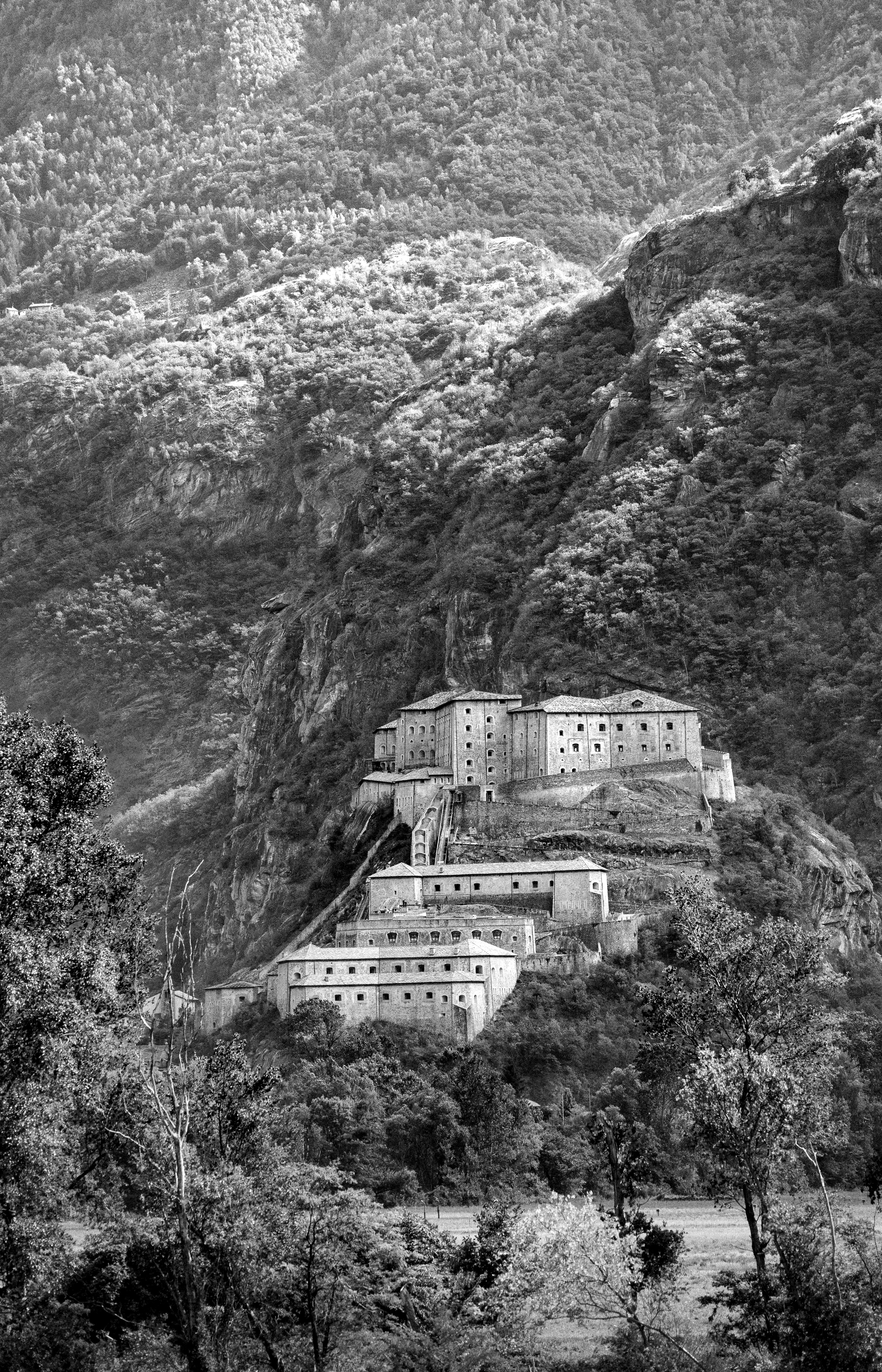 A fort is built on a mountain in black and white.