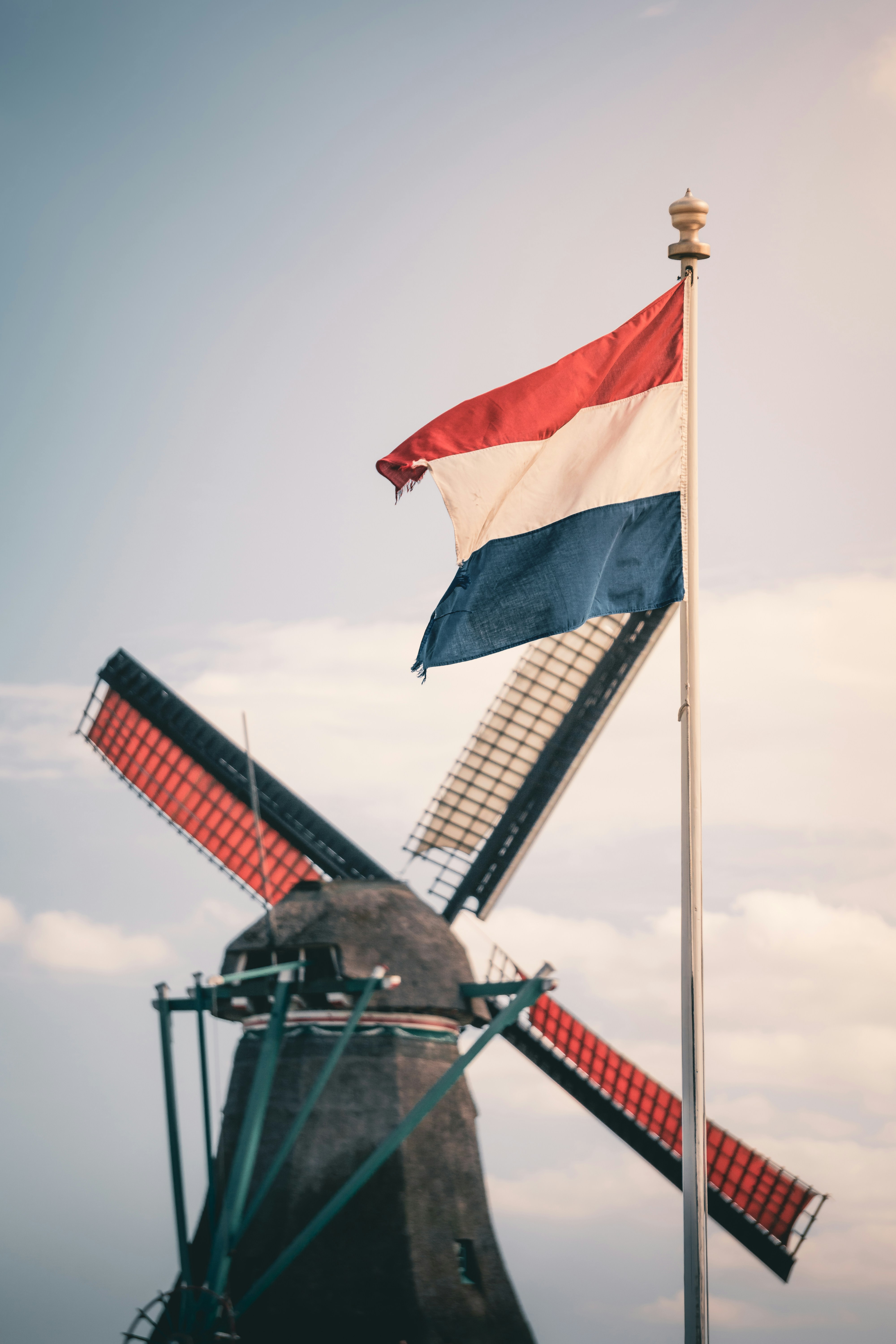 Dutch flag waving near a windmill.