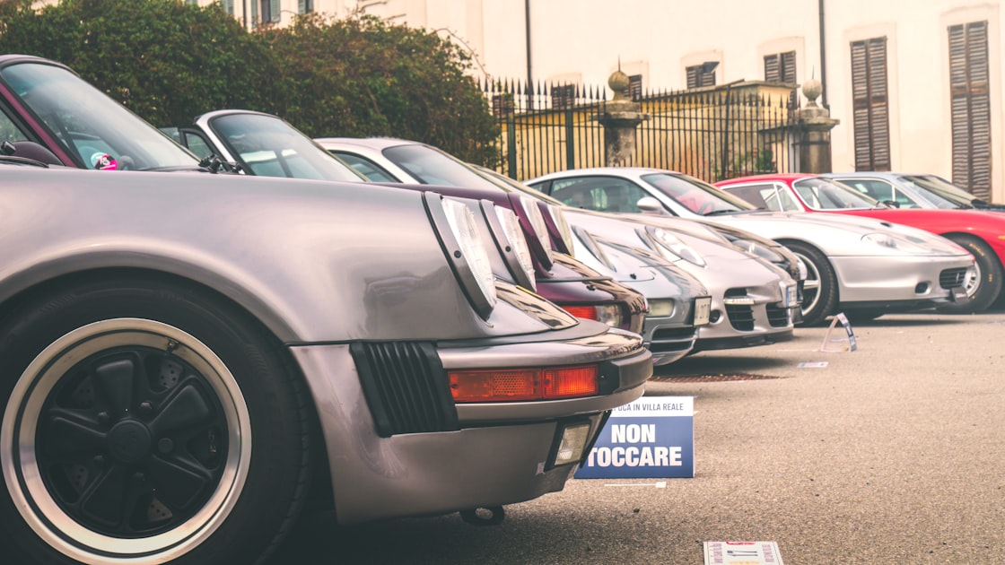 Classic sports cars are parked in a row.
