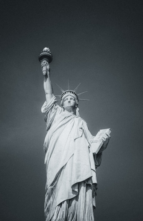 The statue of liberty stands tall in black and white.