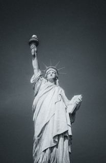 The statue of liberty stands tall in black and white.
