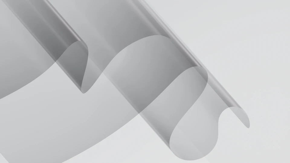 Close-up view of a transparent, curved plastic sheet with a grayish tinted surface