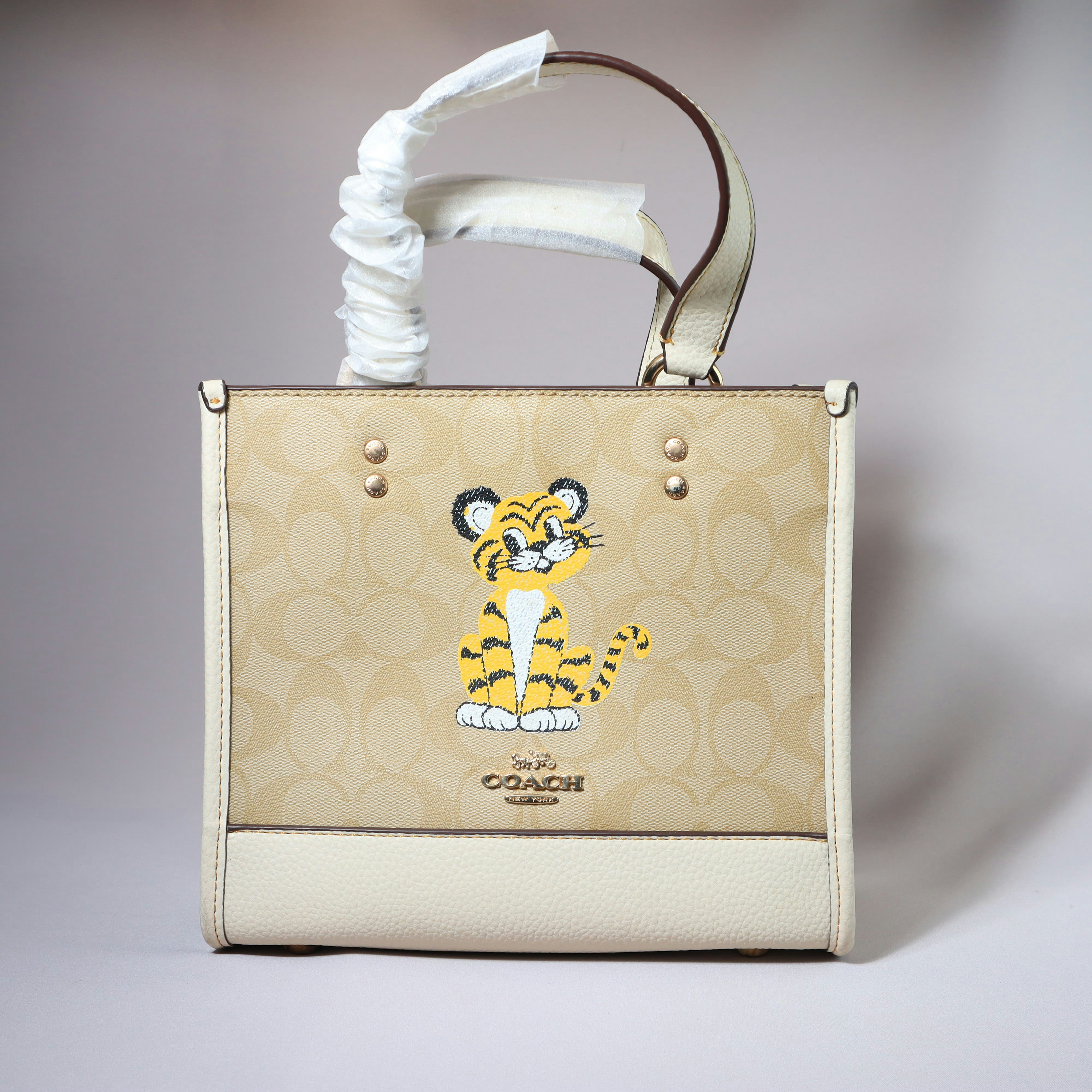 A coach tote bag with a tiger design.