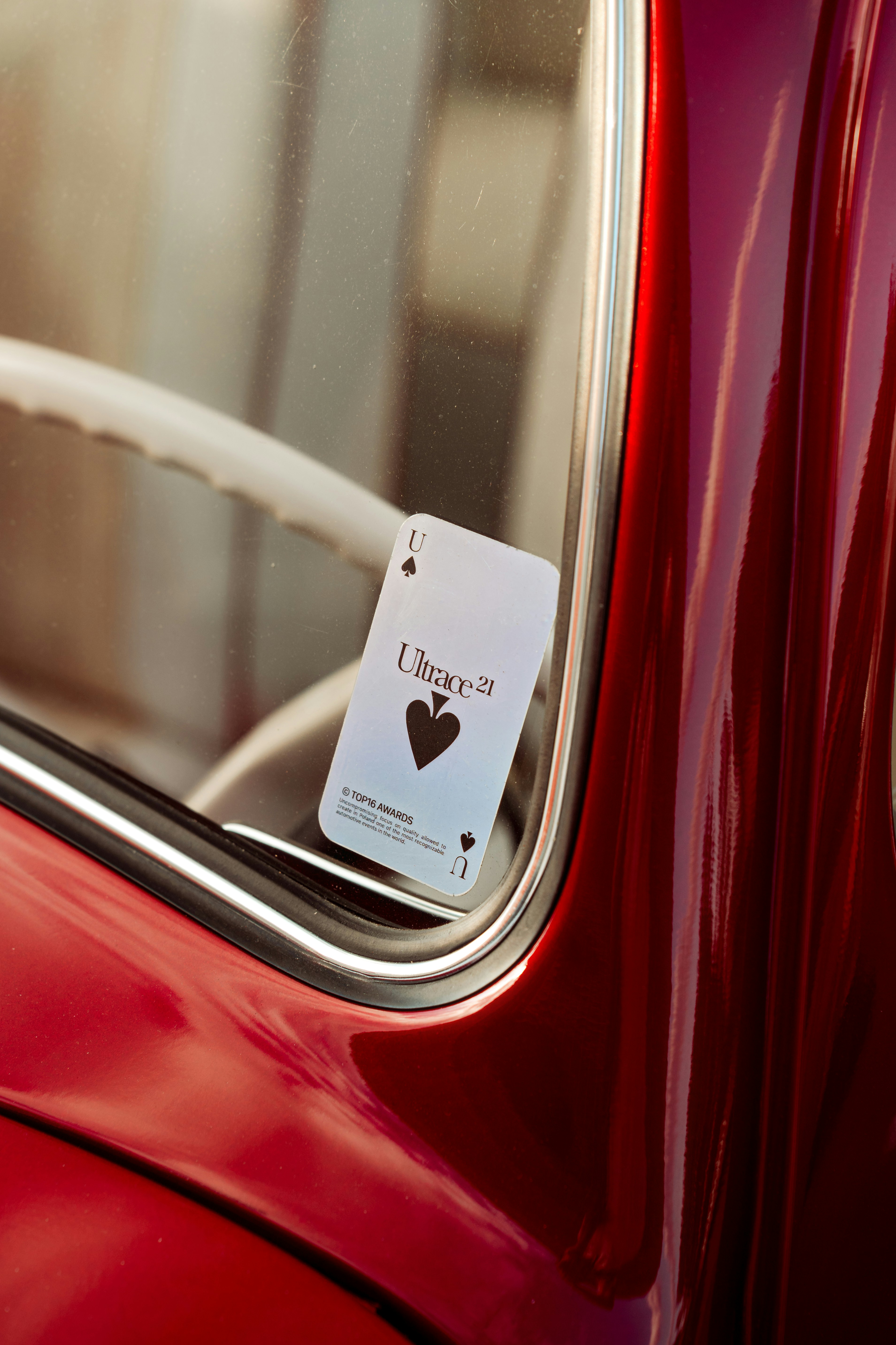 A playing card is stuck inside a car window.