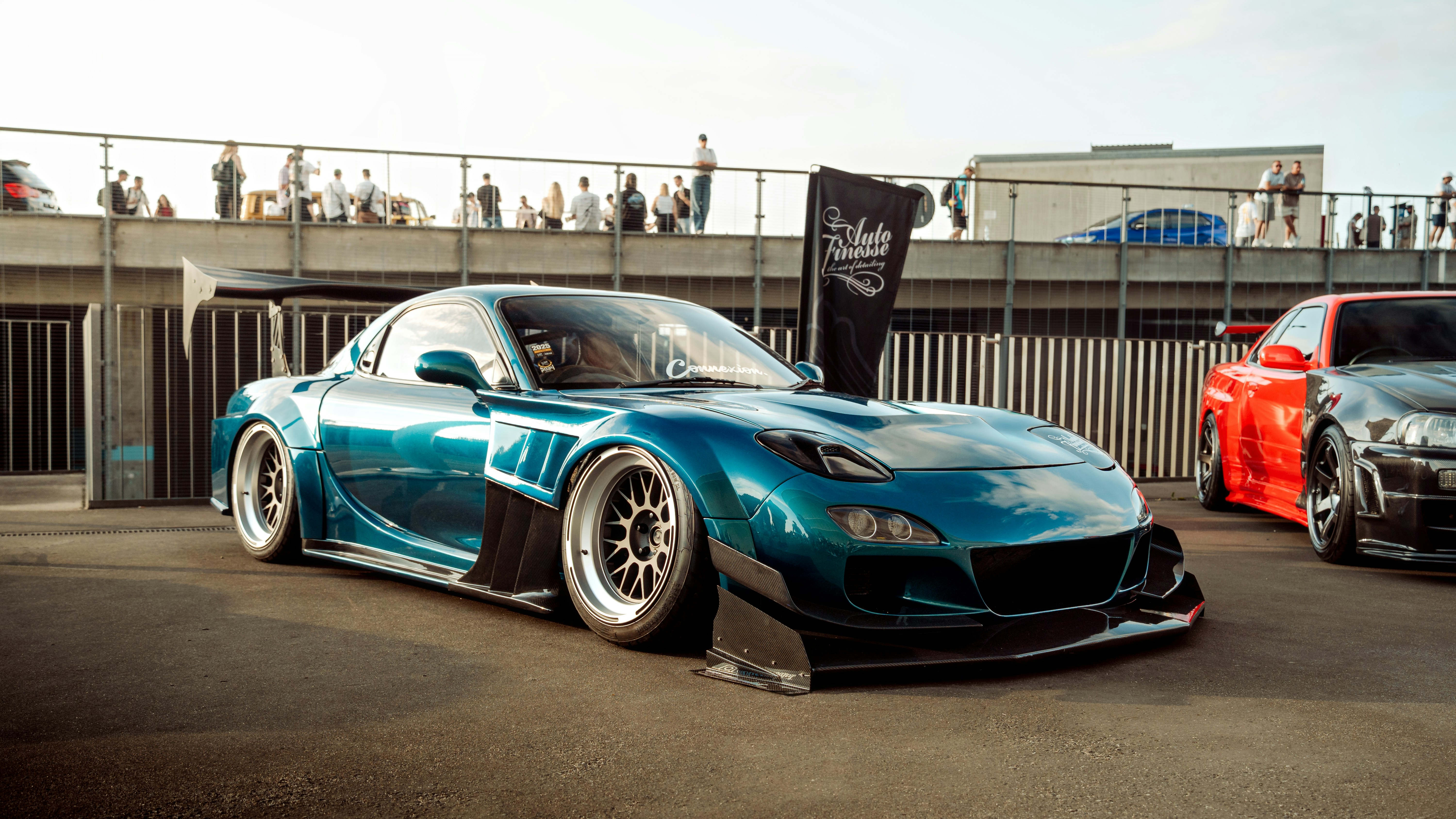 A blue, modified sports car is on display.