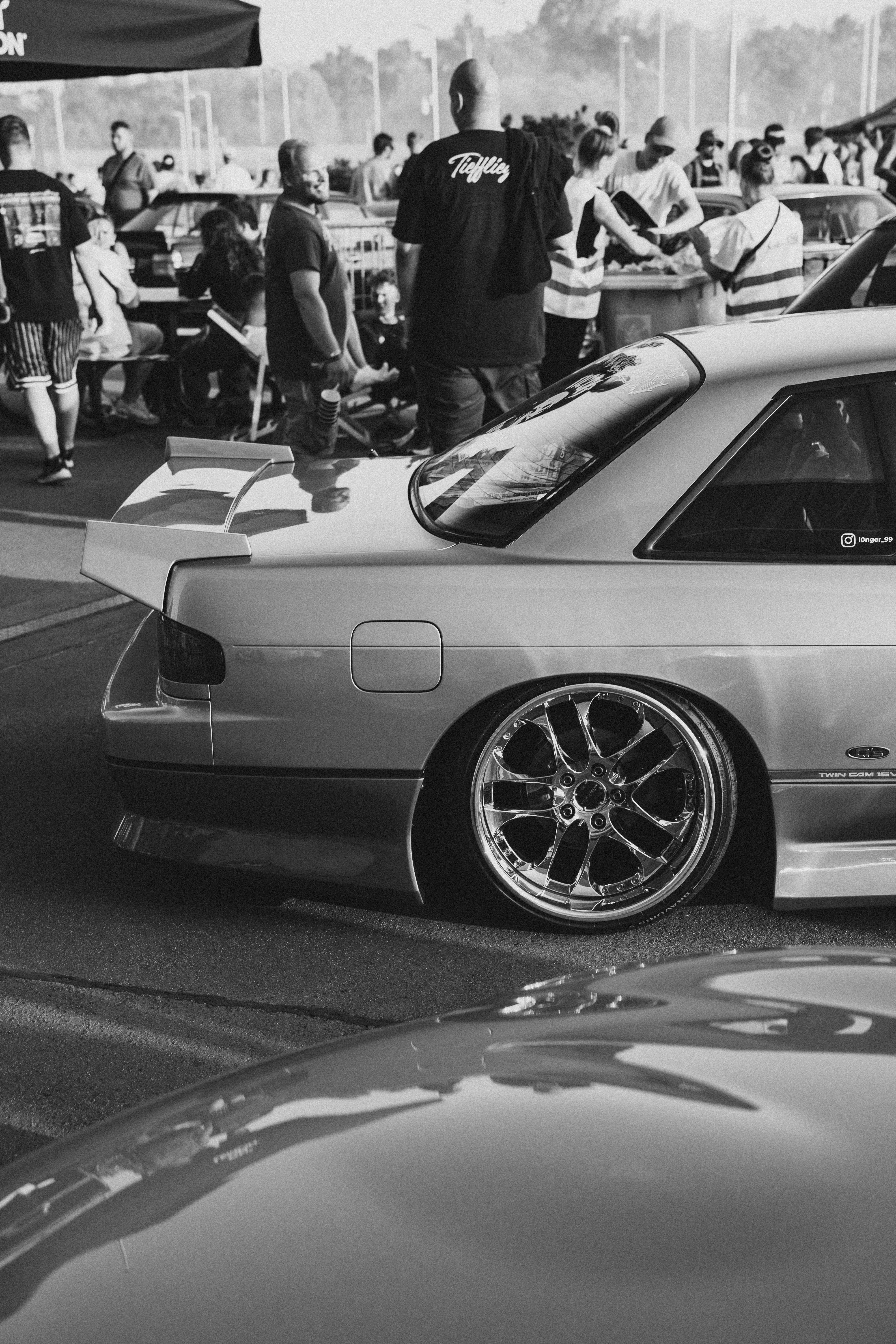 A shiny car is featured at a car meet.
