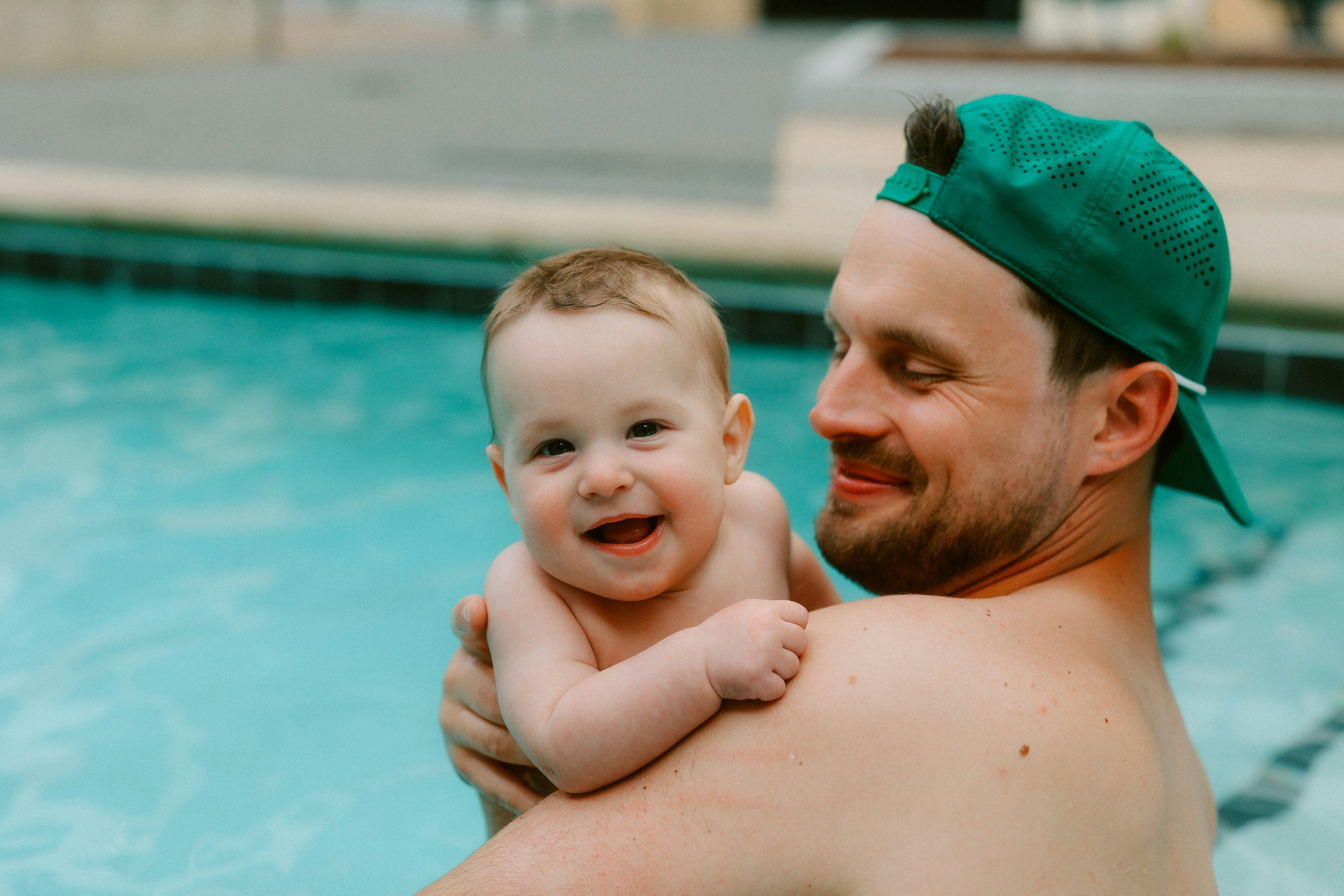 A family smiling and playing in a heated pool during a cool evening - heated pool near me