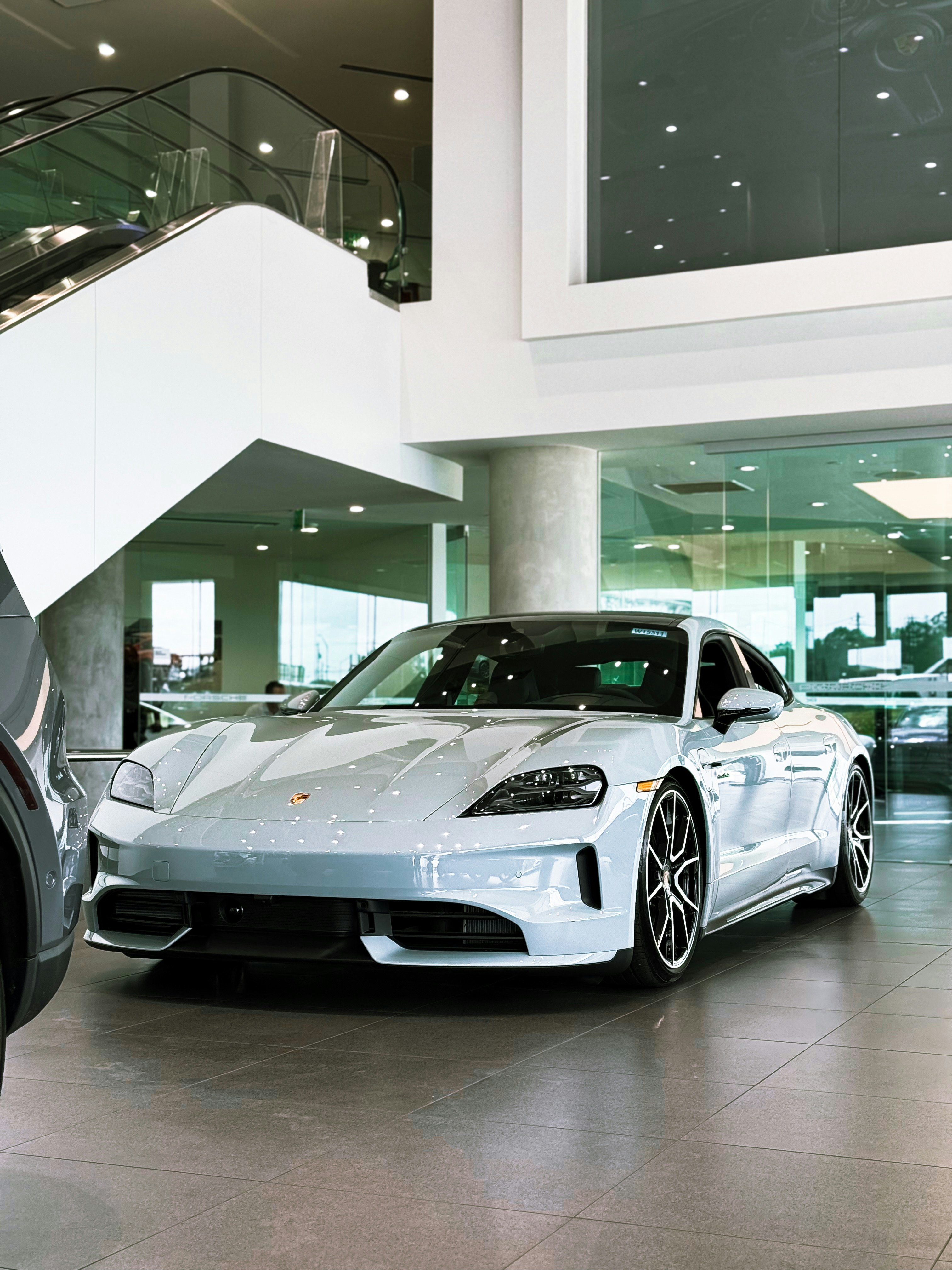 A sleek silver porsche is displayed indoors.