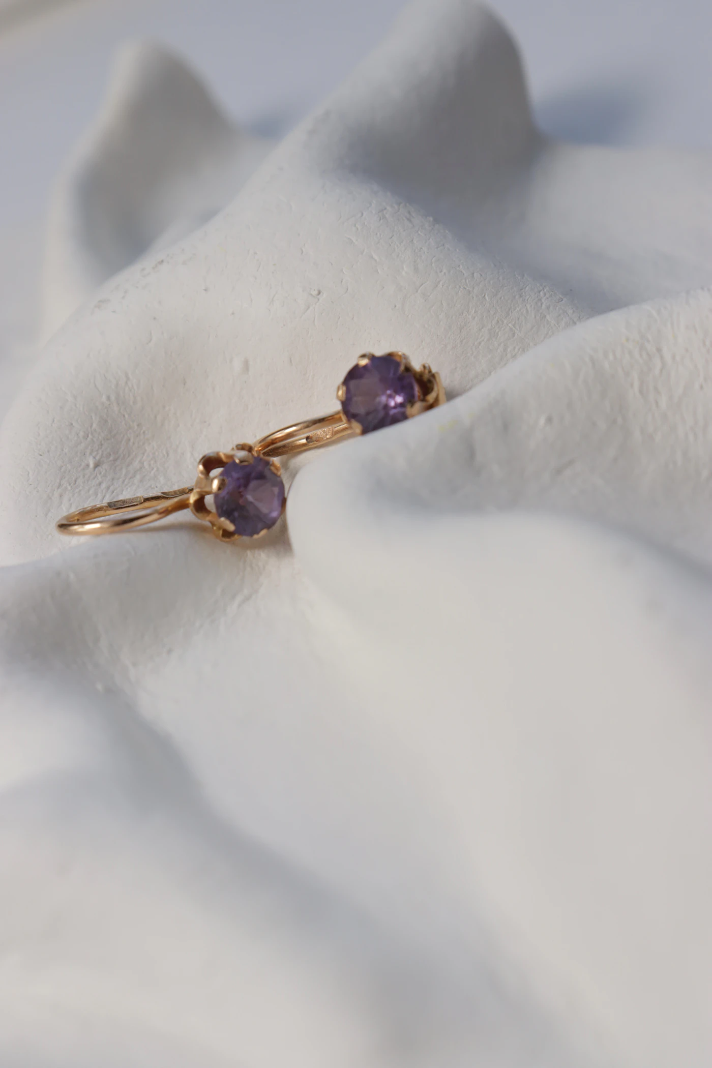Two rings set with purple amethyst gemstones on a white background