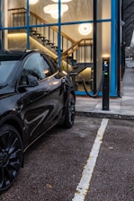 A black tesla is charging at a station.