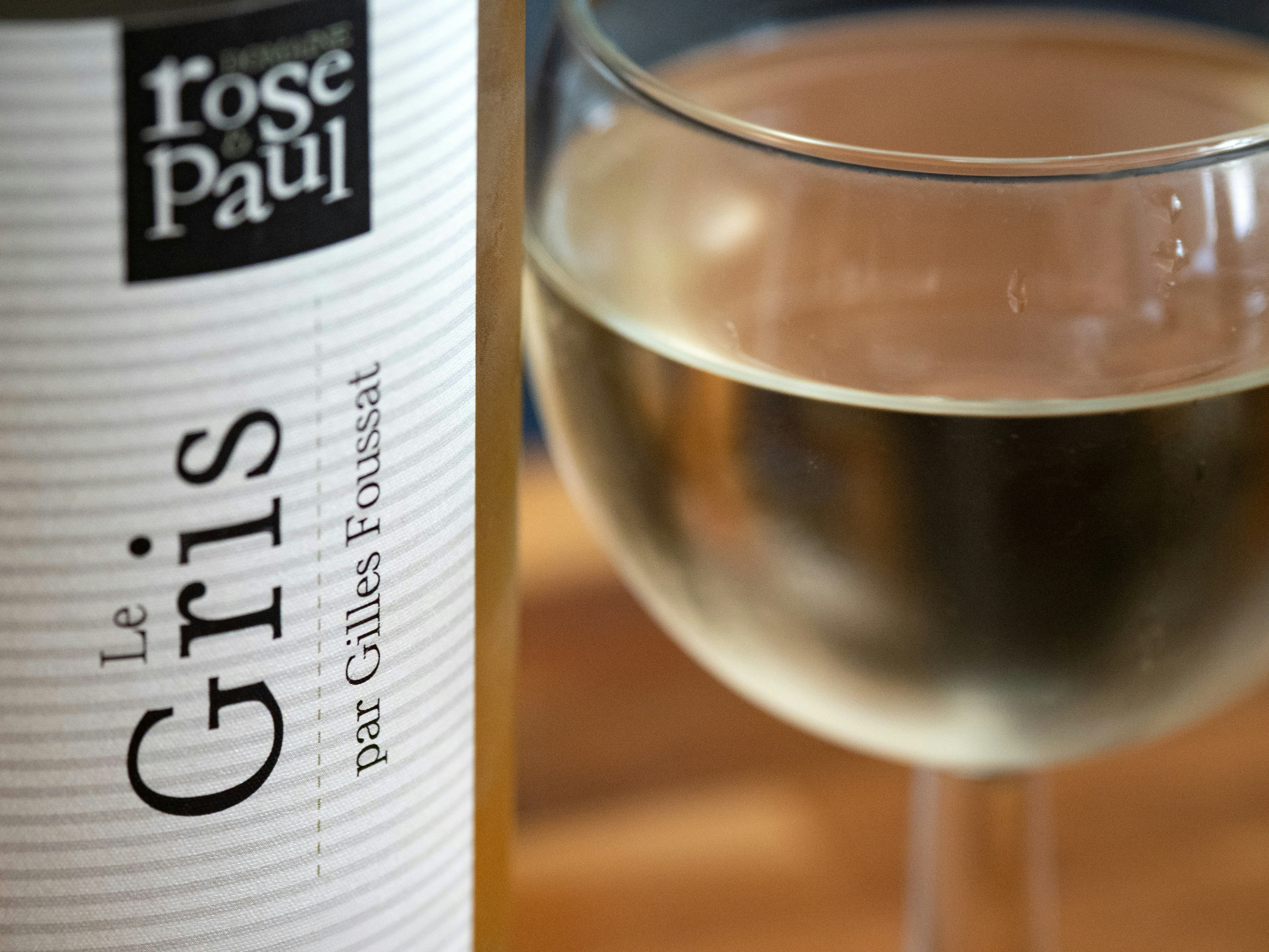 A glass of wine with its bottle.