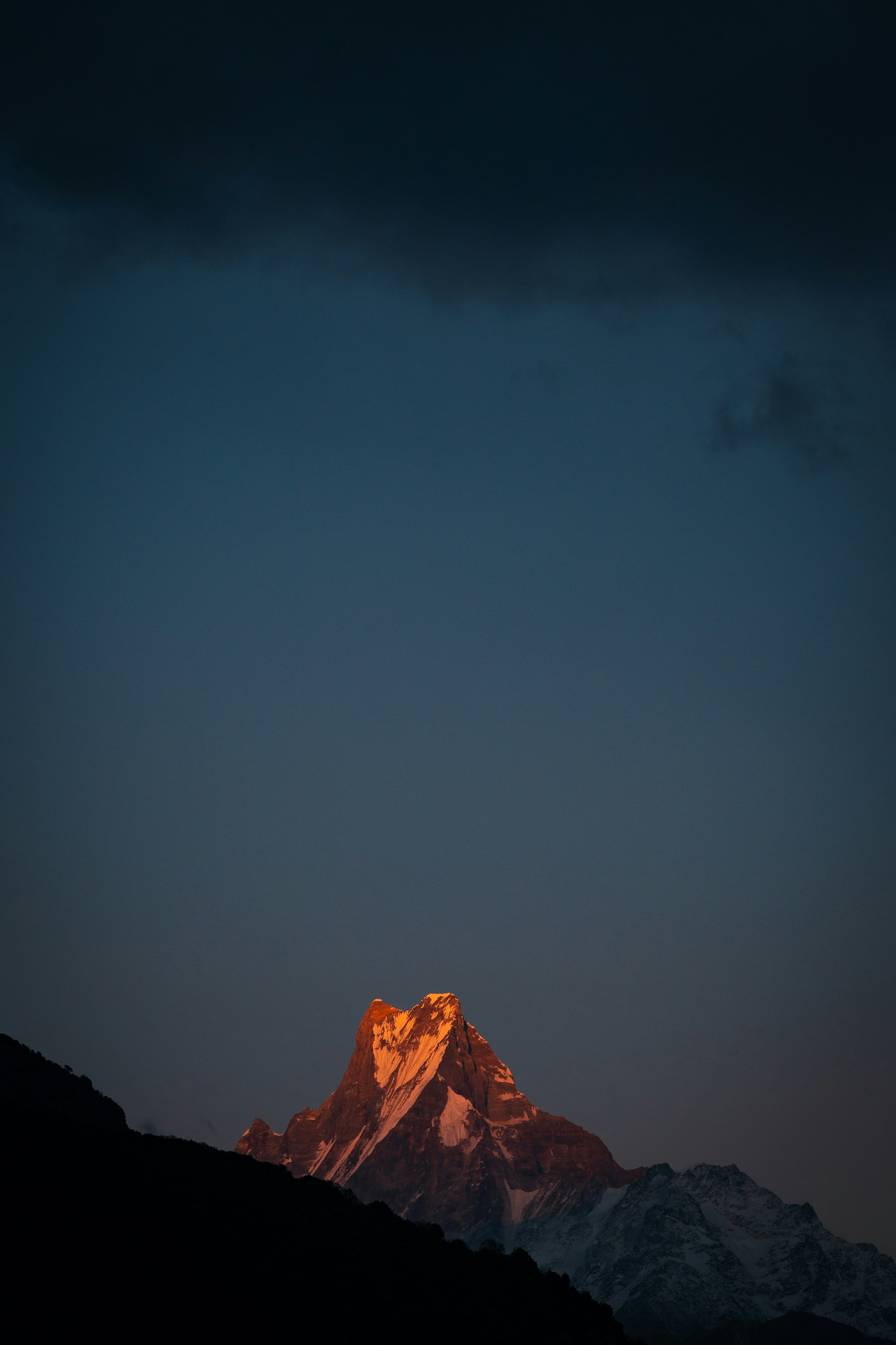 Golden sunlight glints upon a majestic mountain peak.