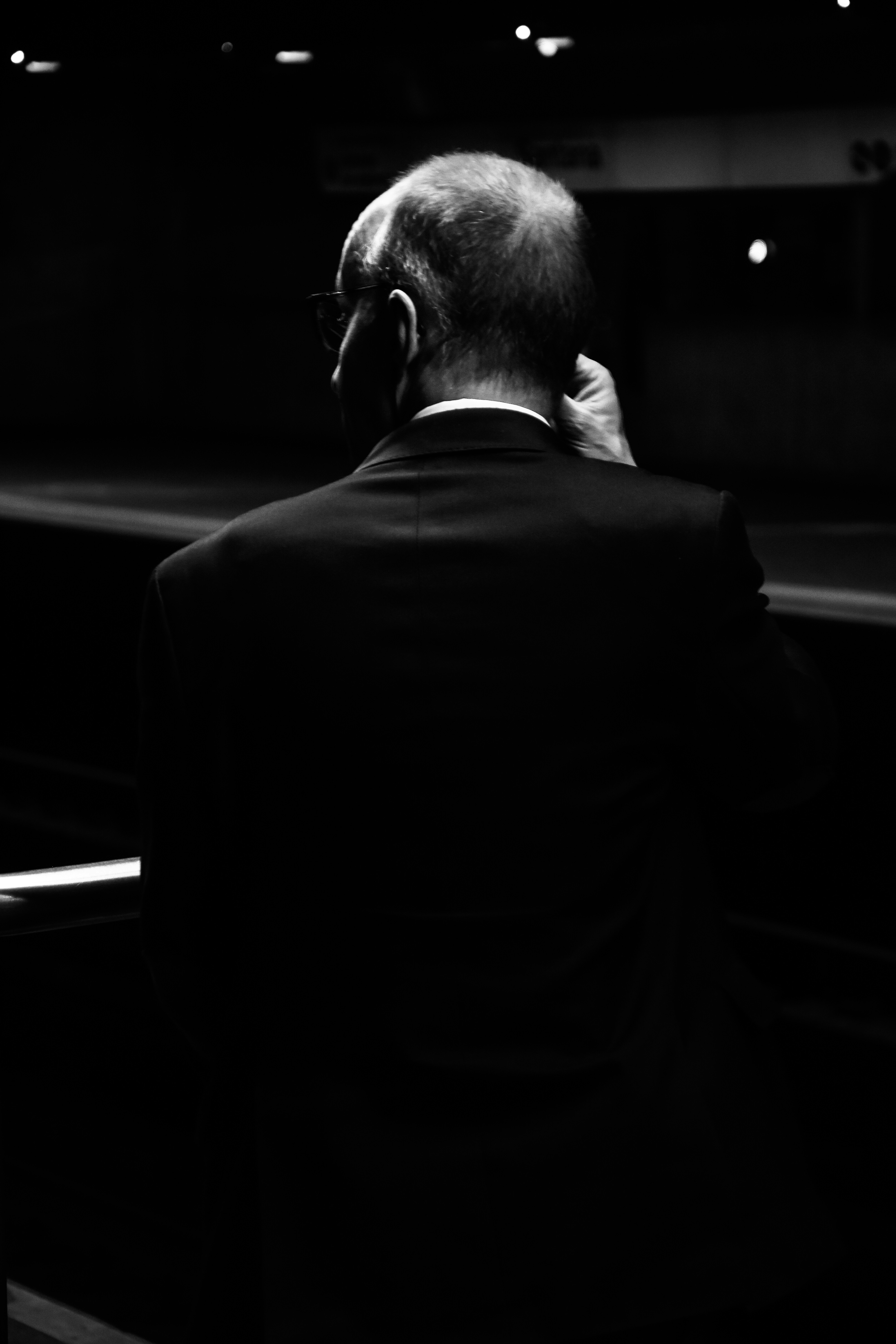 Man in a suit talks on the phone.