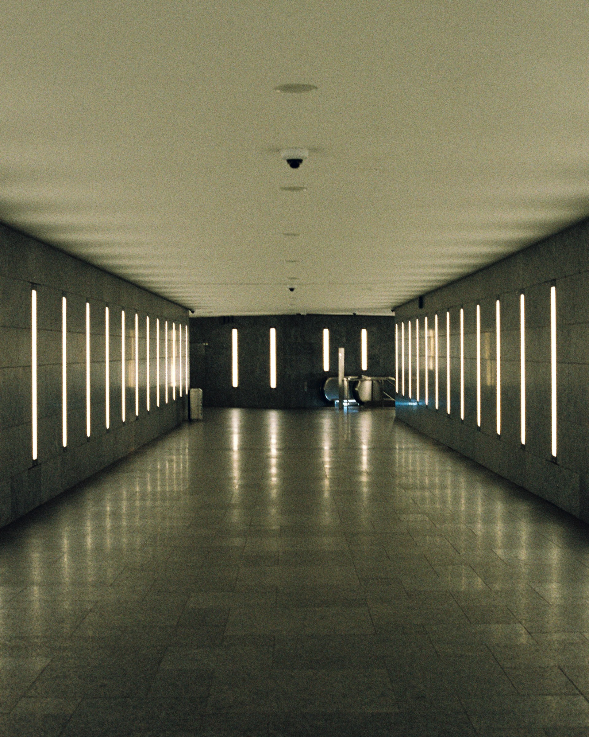 A long, empty hallway with bright lights.