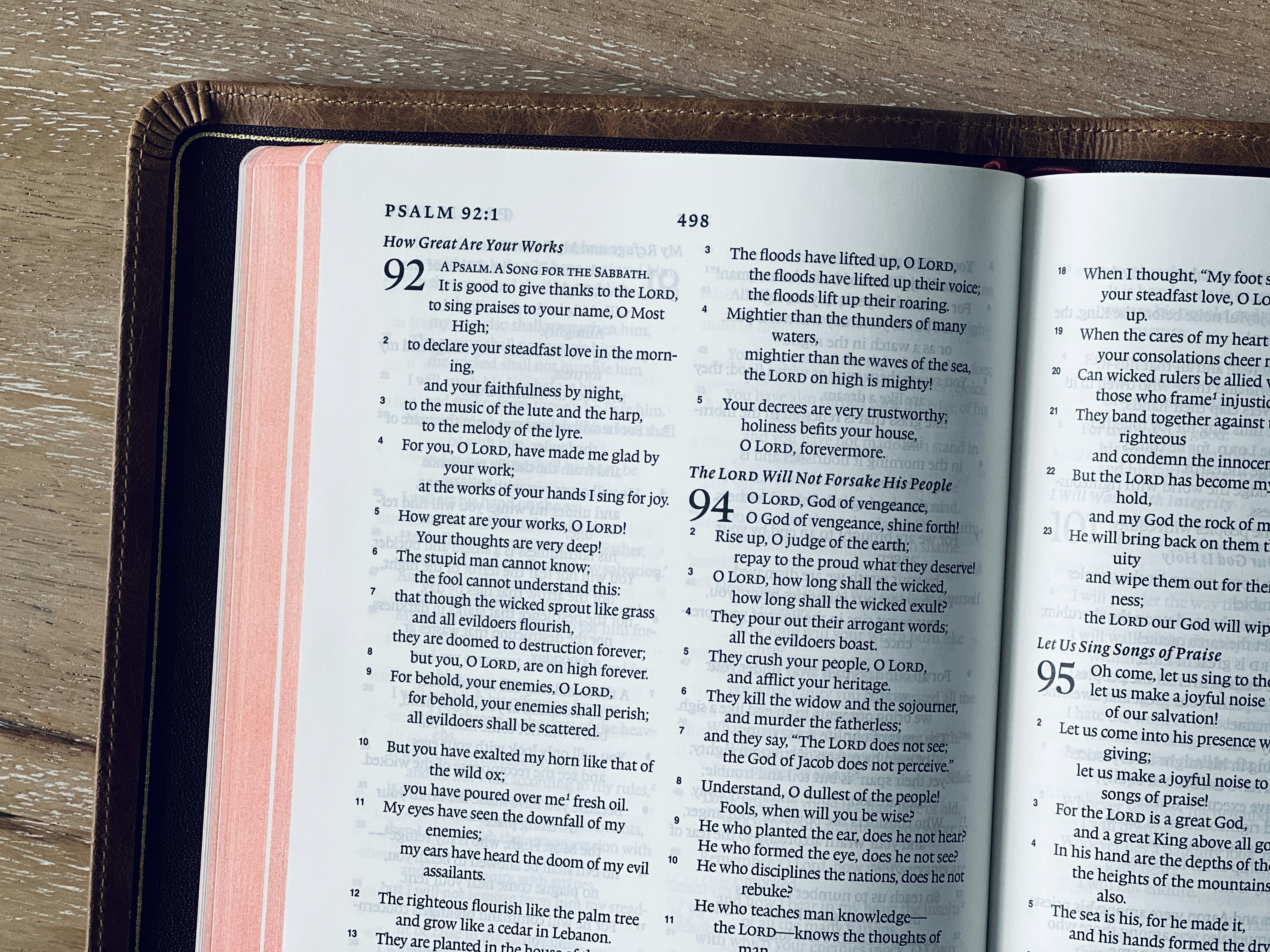 An open bible displays psalm 92 on its pages.