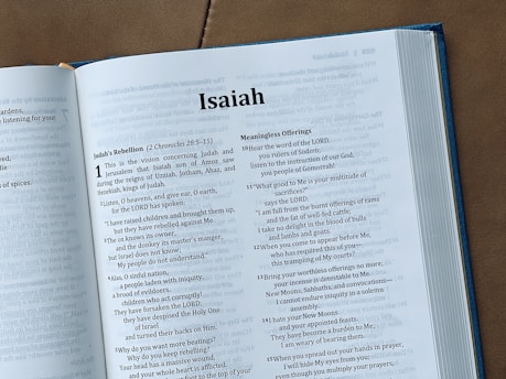 The image shows an open bible with the book of isaiah.