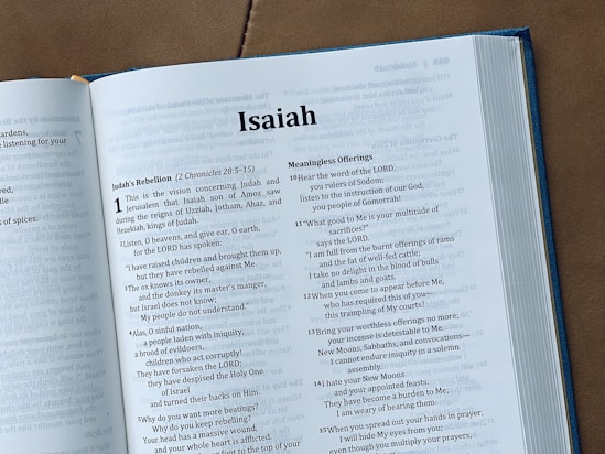 The image shows an open bible with the book of isaiah.