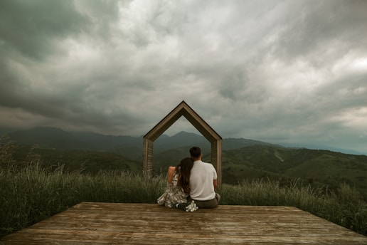 A couple enjoys the landscape through an arch.