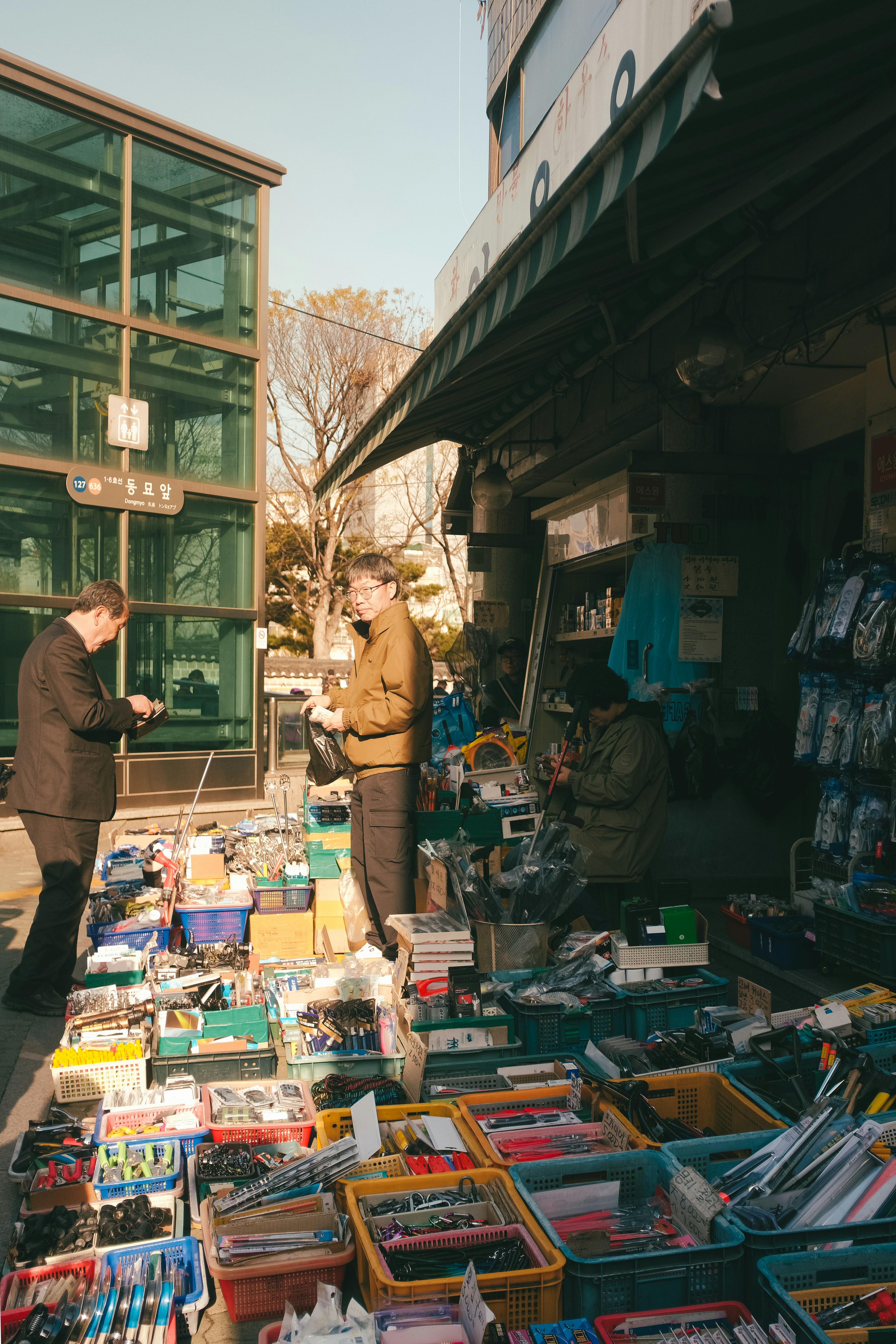 People shop for electronics at an outdoor market.