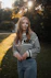 A young woman poses in a park.