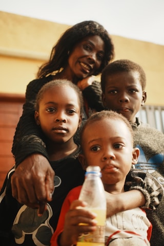 A mother poses with her three children.