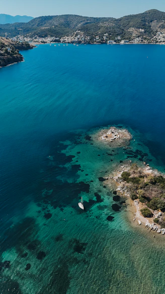 Aerial view of a boat and an island in the ocean.