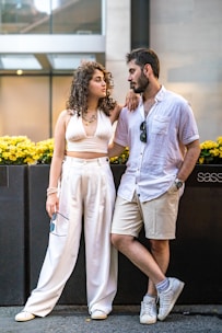 A couple poses together outdoors, looking at each other.