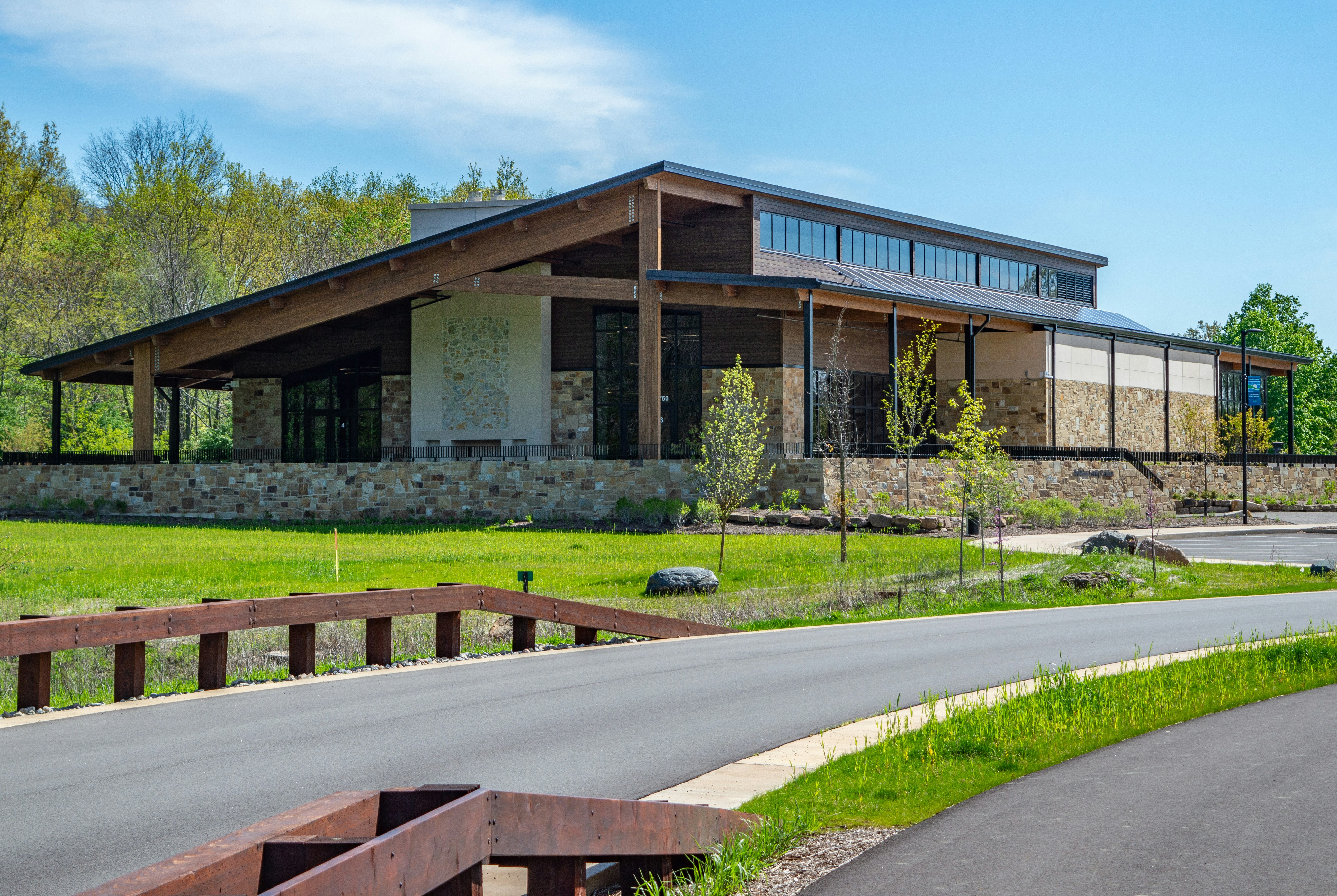 Modern building with stone accents sits in nature.