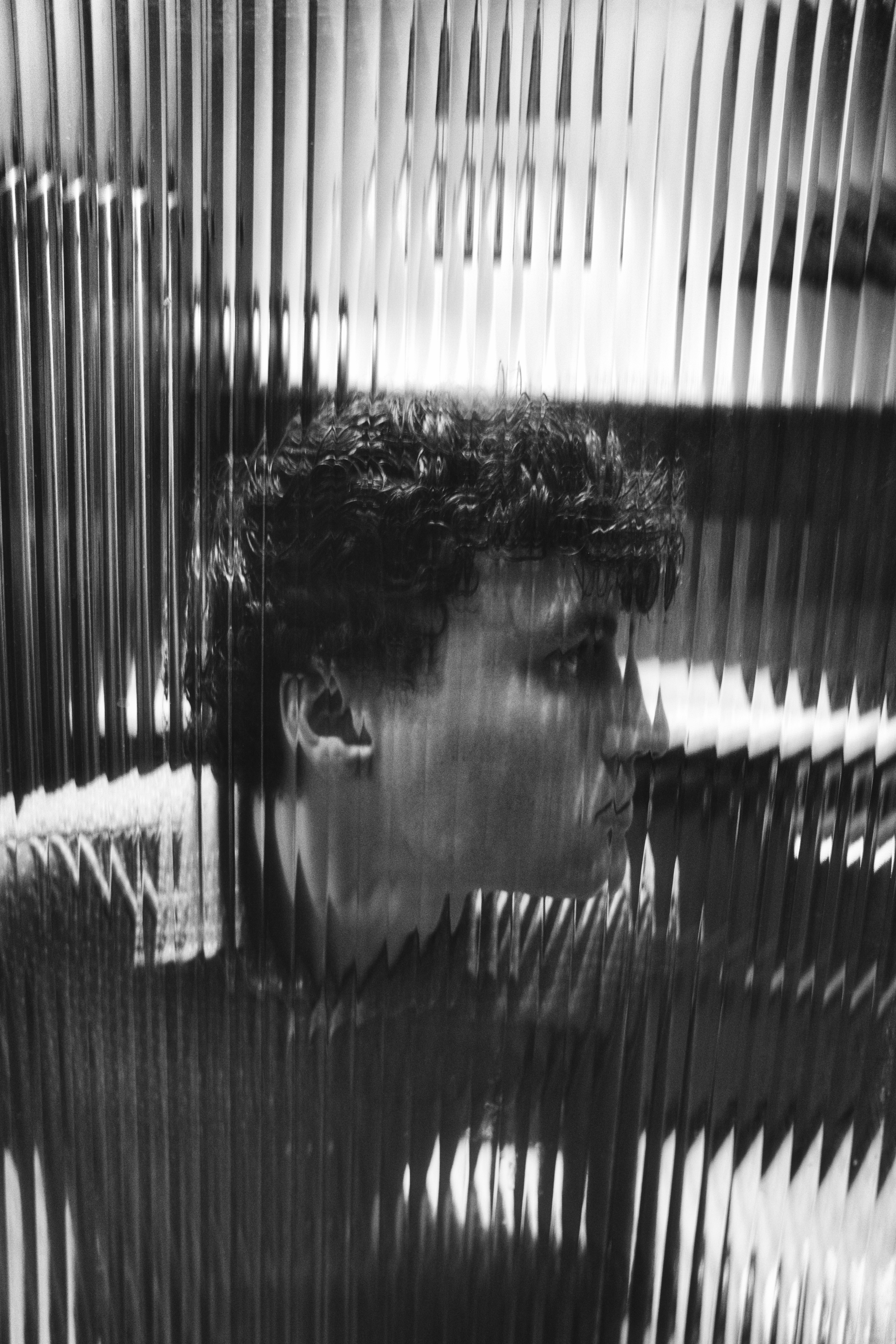 Man's profile is visible through strips.