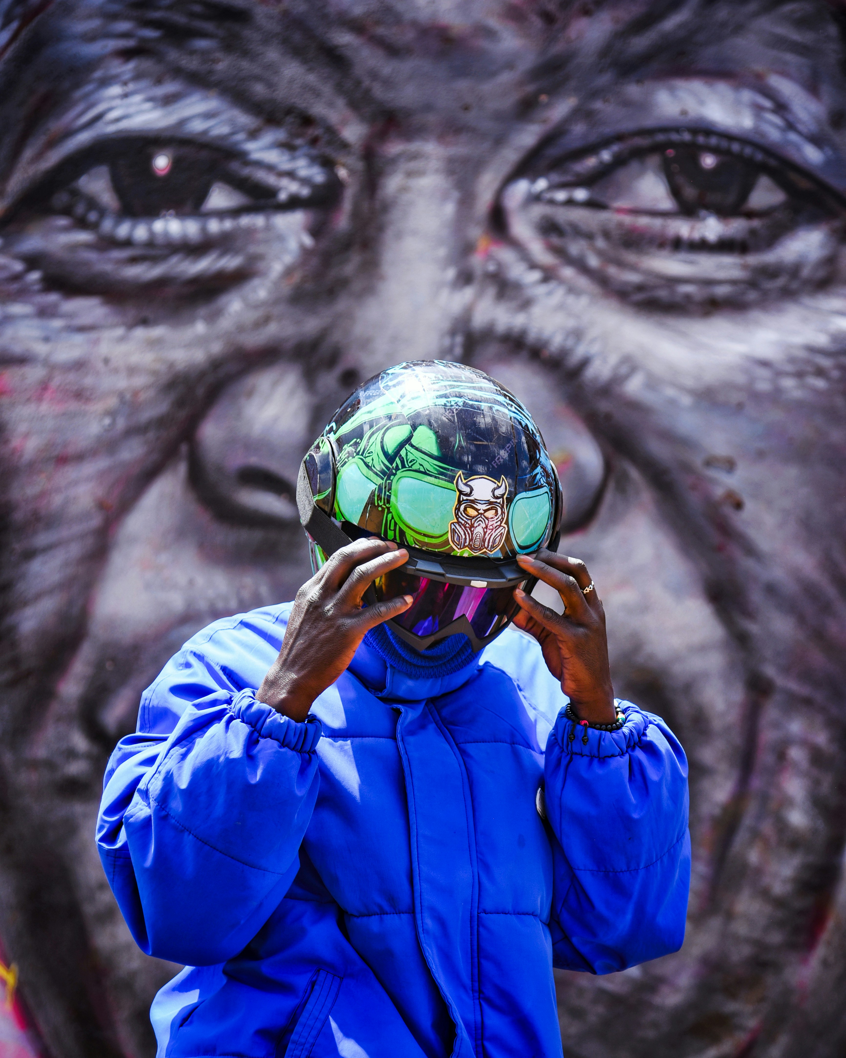 Eine Person rückt vor Graffiti einen Helm zurecht.